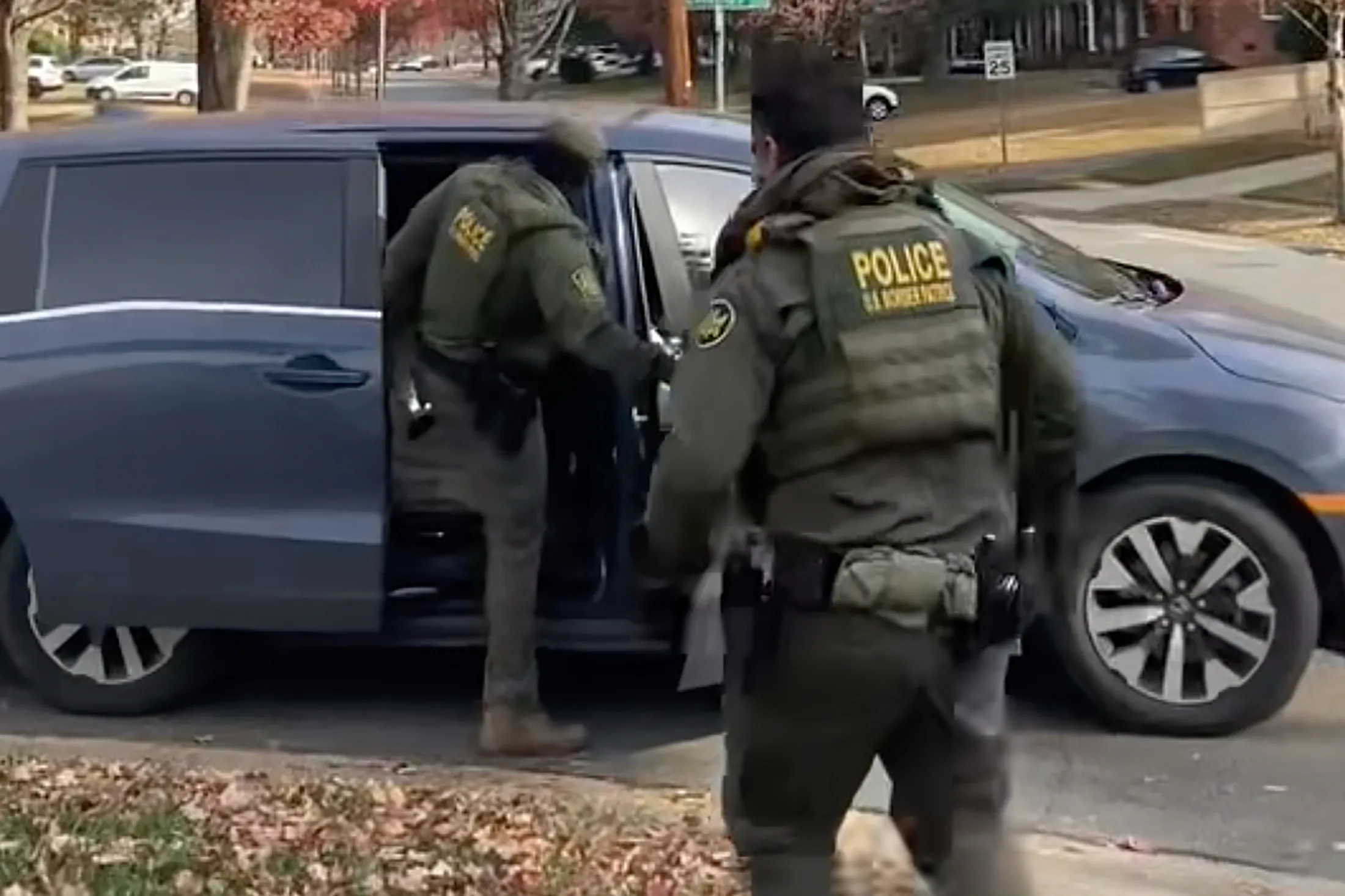 In this image taken from video, US Border Patrol agents leave a yard after approaching two men hanging lights in Charlotte, North Carolina, on Nov. 15.