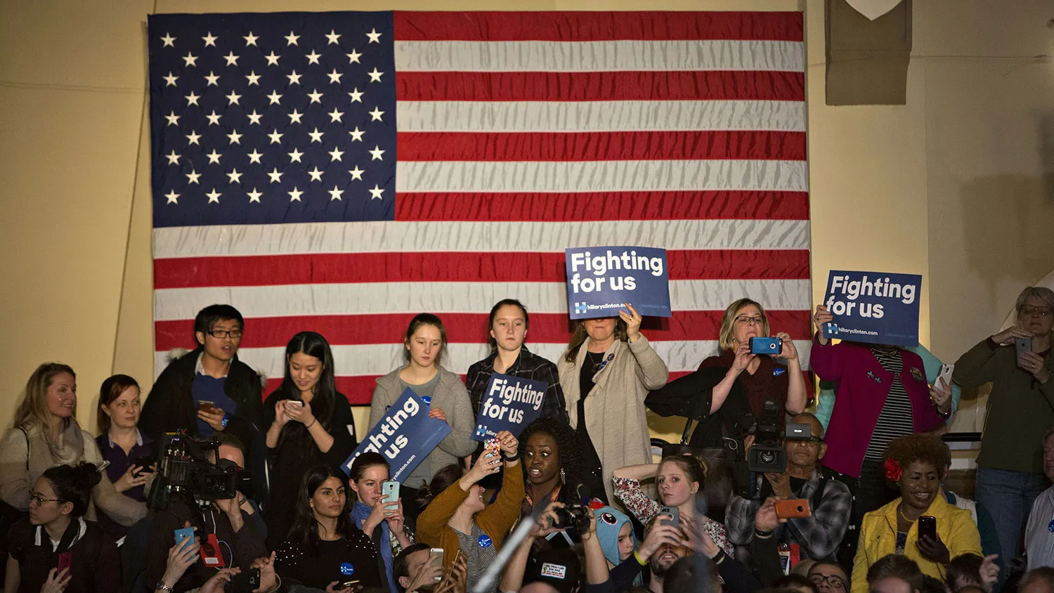 Attendees stand near a U.S. flag during an event with Hillary Clinton and singer Demi Lovato in Iowa City, Iowa, on Jan. 21, 2016.
