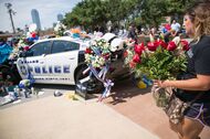 A woman places flowers at a memorial outside the Dallas Police Headquarters on July 8, following the sniper shooting during a peaceful protest the night before.
