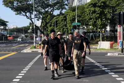 A group of campers carrying a 60kg load in Singapore as part of a training program to be better leaders.