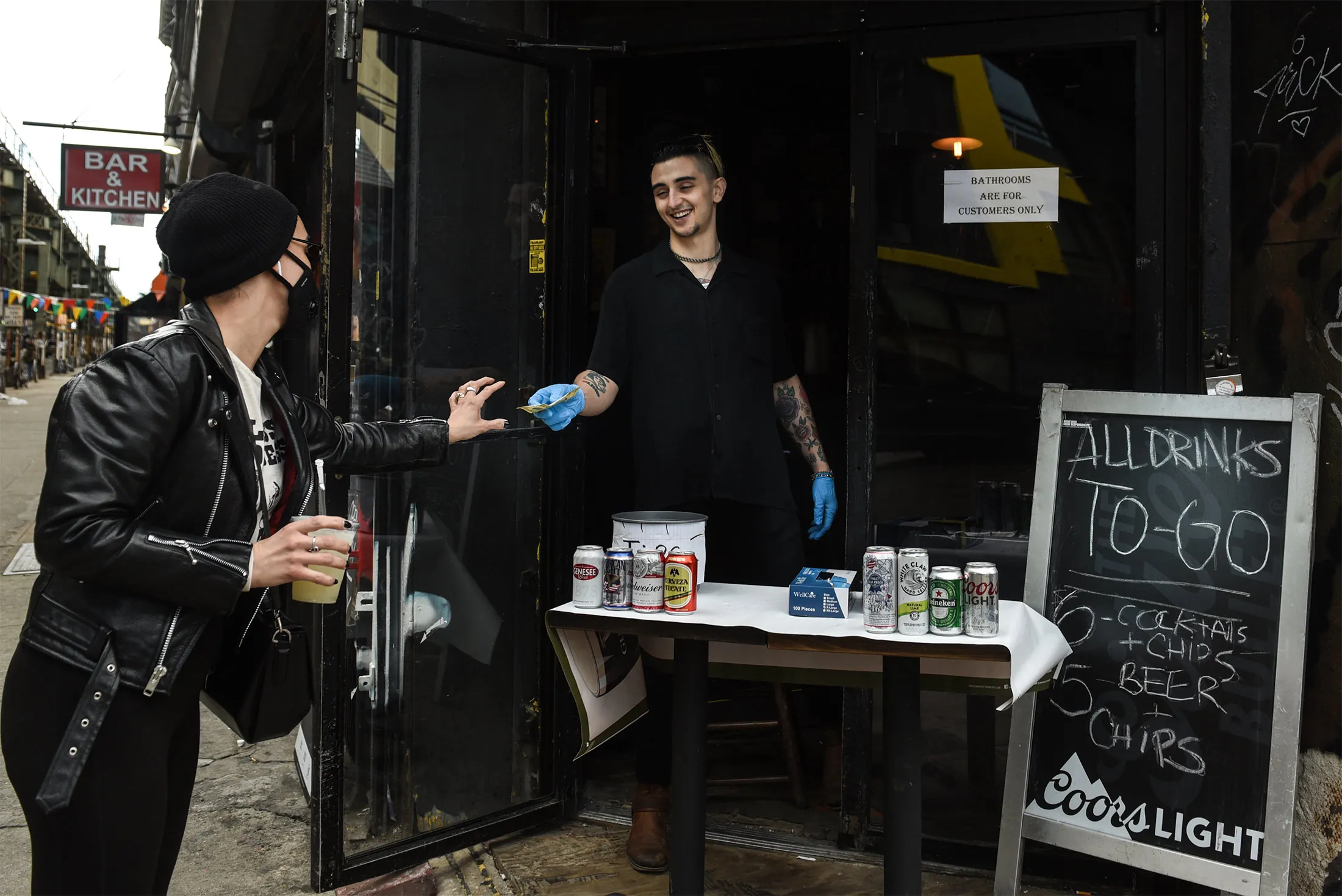 A bartender sells a frozen margarita to go to a customer in Bushwick&nbsp;on&nbsp;April 2, 2020.