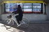 A cyclist rides past an electronic stock board showing a figure of the Nikkei Stock Average outside a securities firm in Tokyo, Japan, on Friday, Jan. 12, 2018.