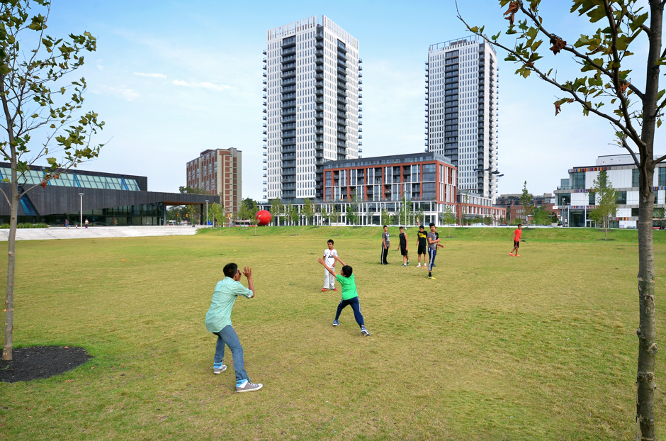 Children play in a large green space in the redeveloped Regent Park neighborhood.