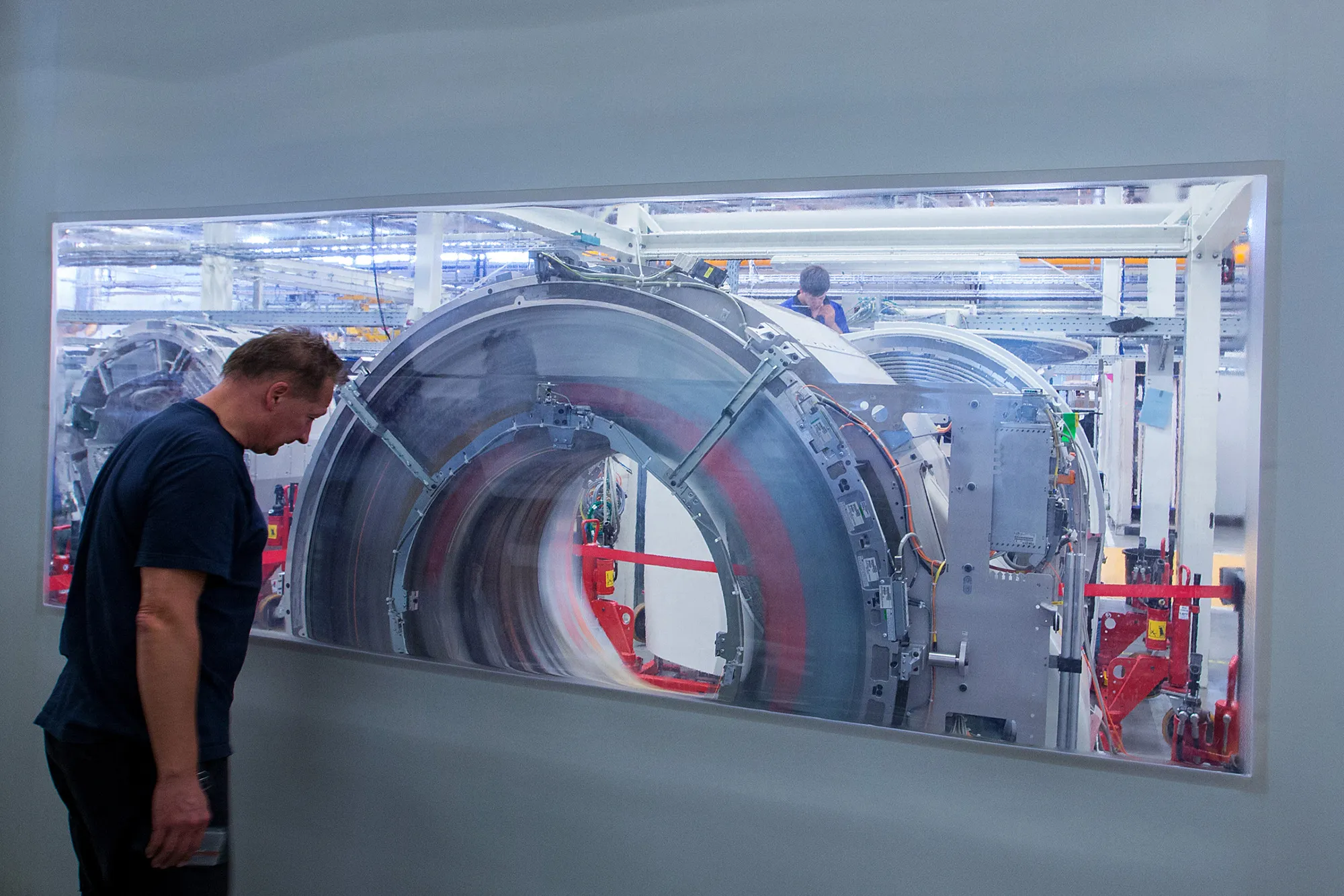 An employee watches drive mechanism testing on a Siemens Somatom computerized tomography (CT) scanner machine at the Siemens AG Healthineers factory in Forchheim, Germany, on Wednesday, July 19, 2017. Siemens said it's moving ahead with a planned split from its health-care division as Europe's largest engineering company whittles down its core holdings to focus on energy and factory equipment.