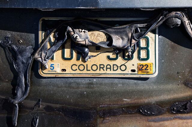 Plastic is melted over a Colorado license plate in a neighborhood decimated by the Marshall Fire