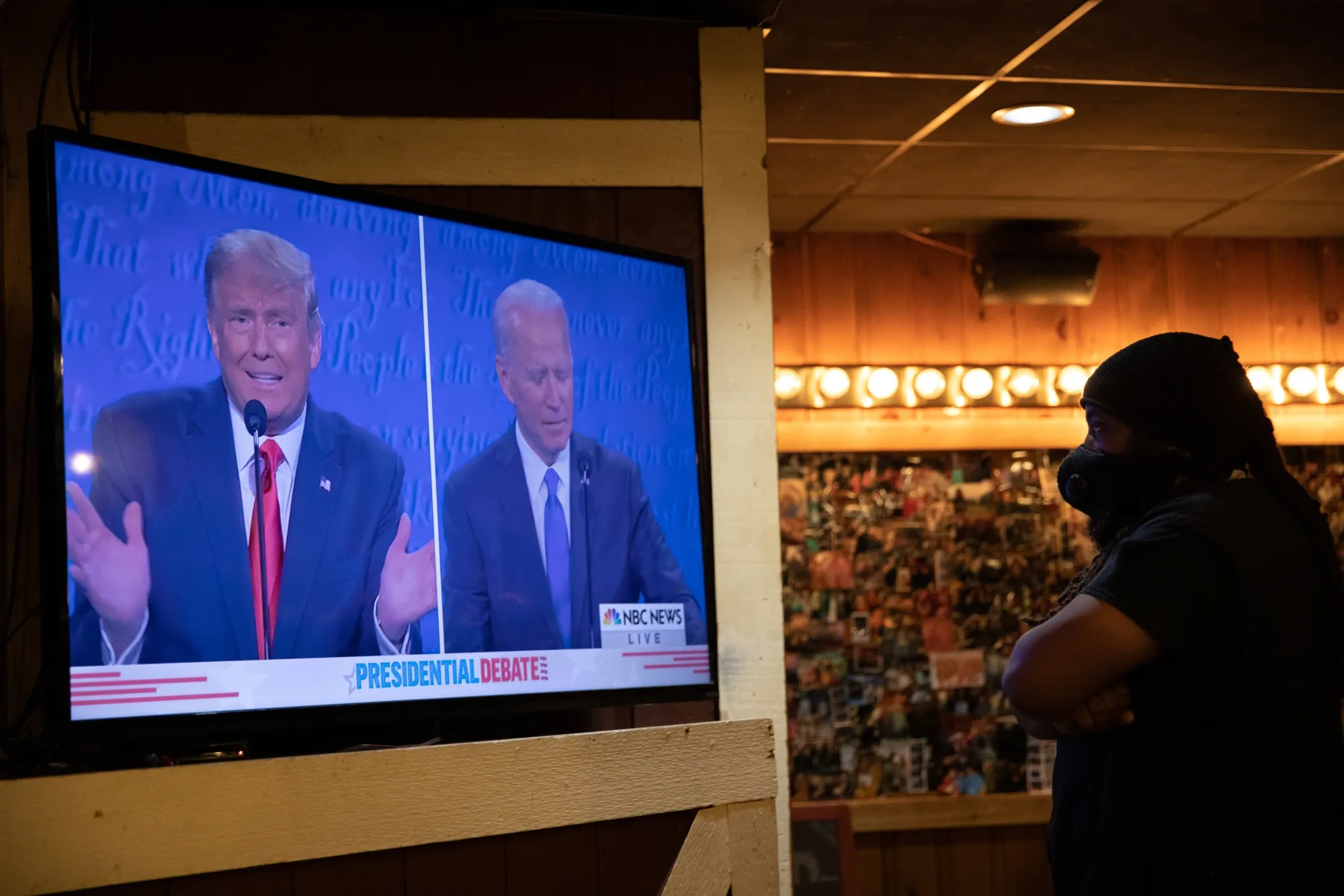 A bartender wearing watches the U.S. presidential debate between Donald Trump and Joe Biden at a bar in Clawson, Michigan, on Oct. 22, 2020.