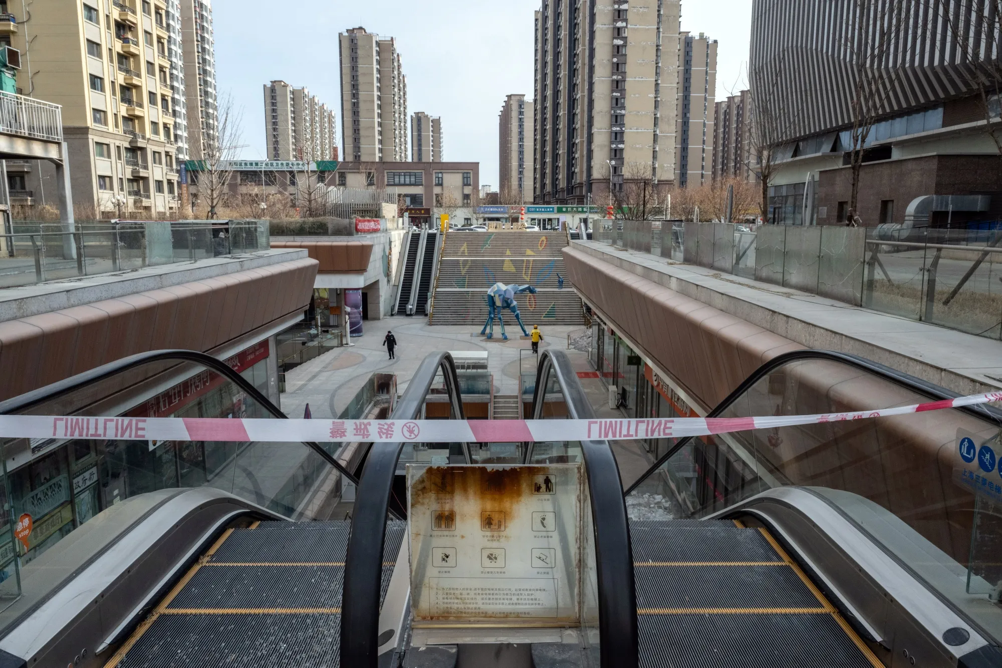 Barrier tape across escalators at the near deserted Evergrande City Plaza shopping mall, developed by China Evergrande Group, in Beijing, China, on Wednesday, Jan. 31, 2024.