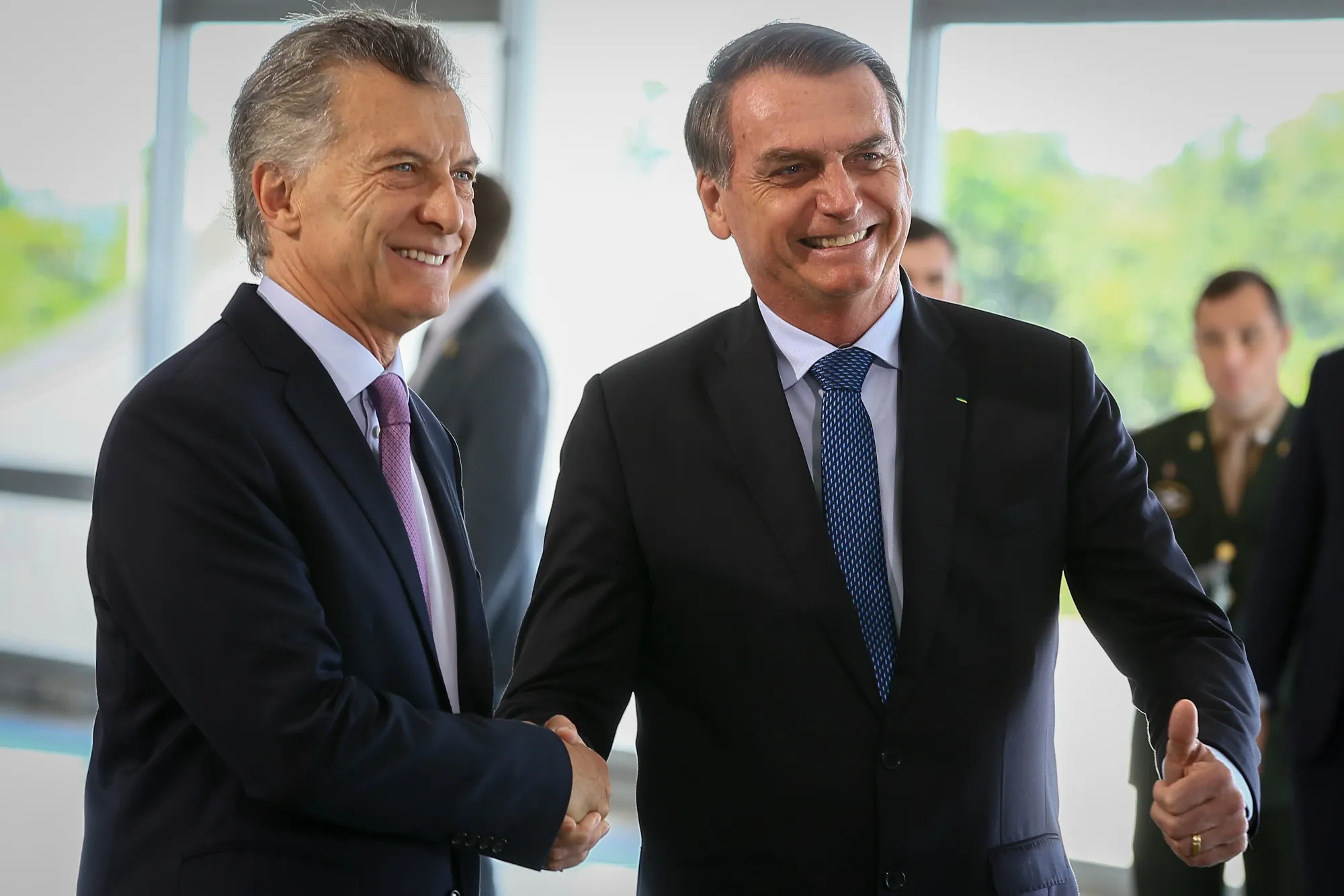 Jair Bolsonaro, Brazil's president, gives a thumbs up sign while shaking hands with Mauricio Macri, Argentina's president, left, before a joint news conference at Planalto Palace in Brasilia,&nbsp;on&nbsp;Jan. 16.&nbsp;