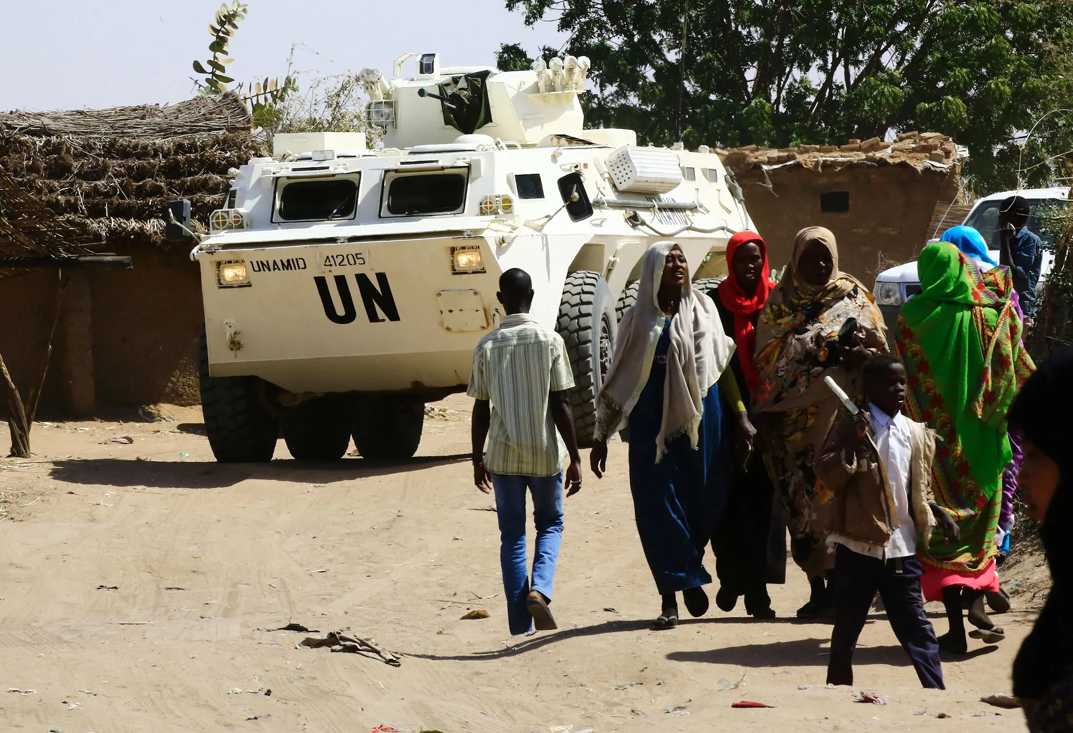Sudanese refugees walk past a UN vehicle at a UN refugee camp in the city of Nyala, in South Darfur, on Jan. 9.
