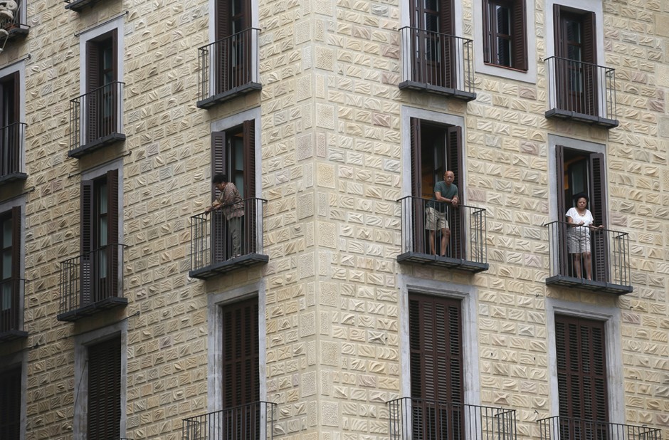 People look at the view from an apartment at Sant Jaume square at Gothic quarter in Barcelona.