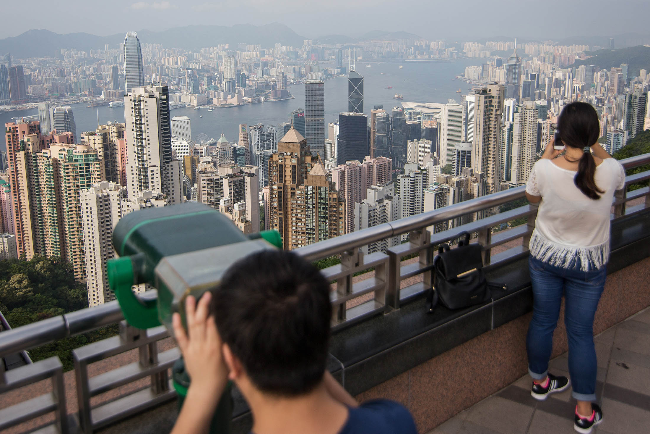 Tourists look at the view from Victoria Peak in Hong Kong. Hong Kong and mainland markets are at the epicenter of a global stock slump fueled by concern about China’s sliding currency and economic management.
