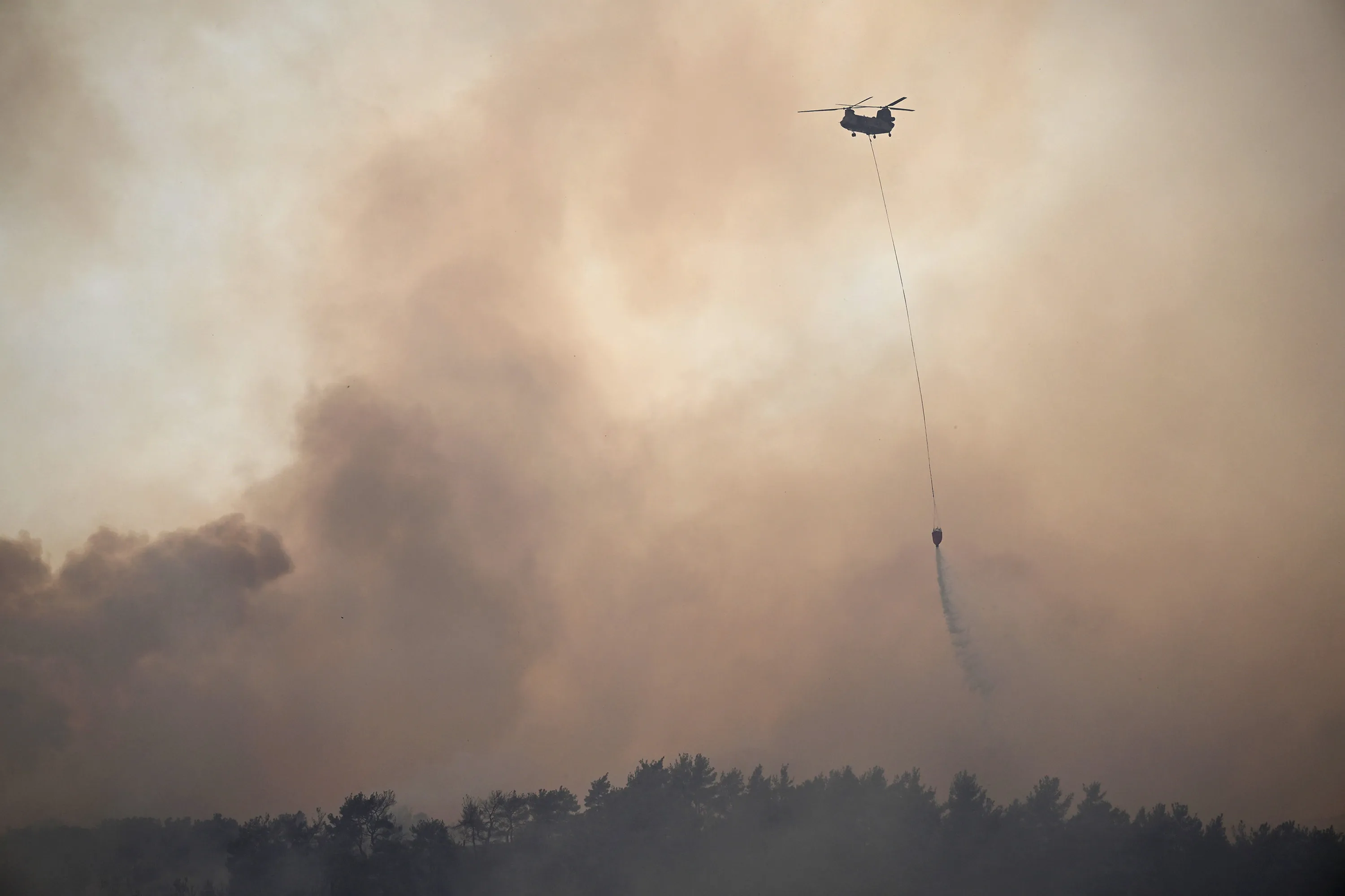 A helicopter drops water on a fire near Kayadere in Canakkale, Turkey, on Aug. 23.