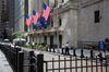 A person rests on a post in front of the New York Stock Exchange (NYSE) in New York, U.S., on Friday, Oct. 2, 2020. New York faced pressure as middle and high schools reopened, infection rates in virus hot spots rose further and the city's bond rating was cut by Moody's.