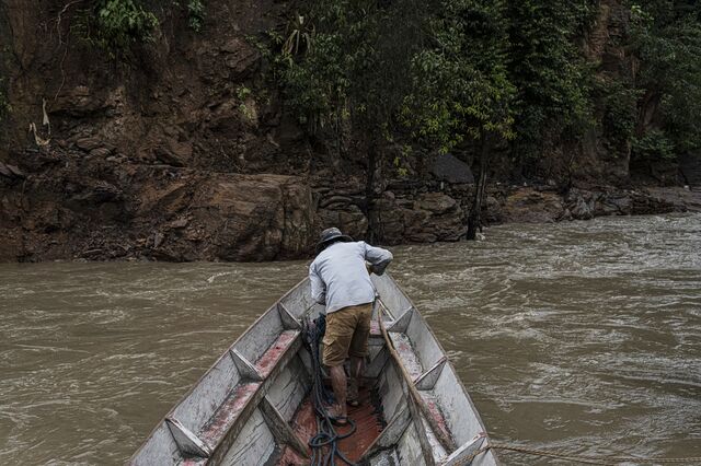 A man ferries vehicles across the river in Cangalli. 