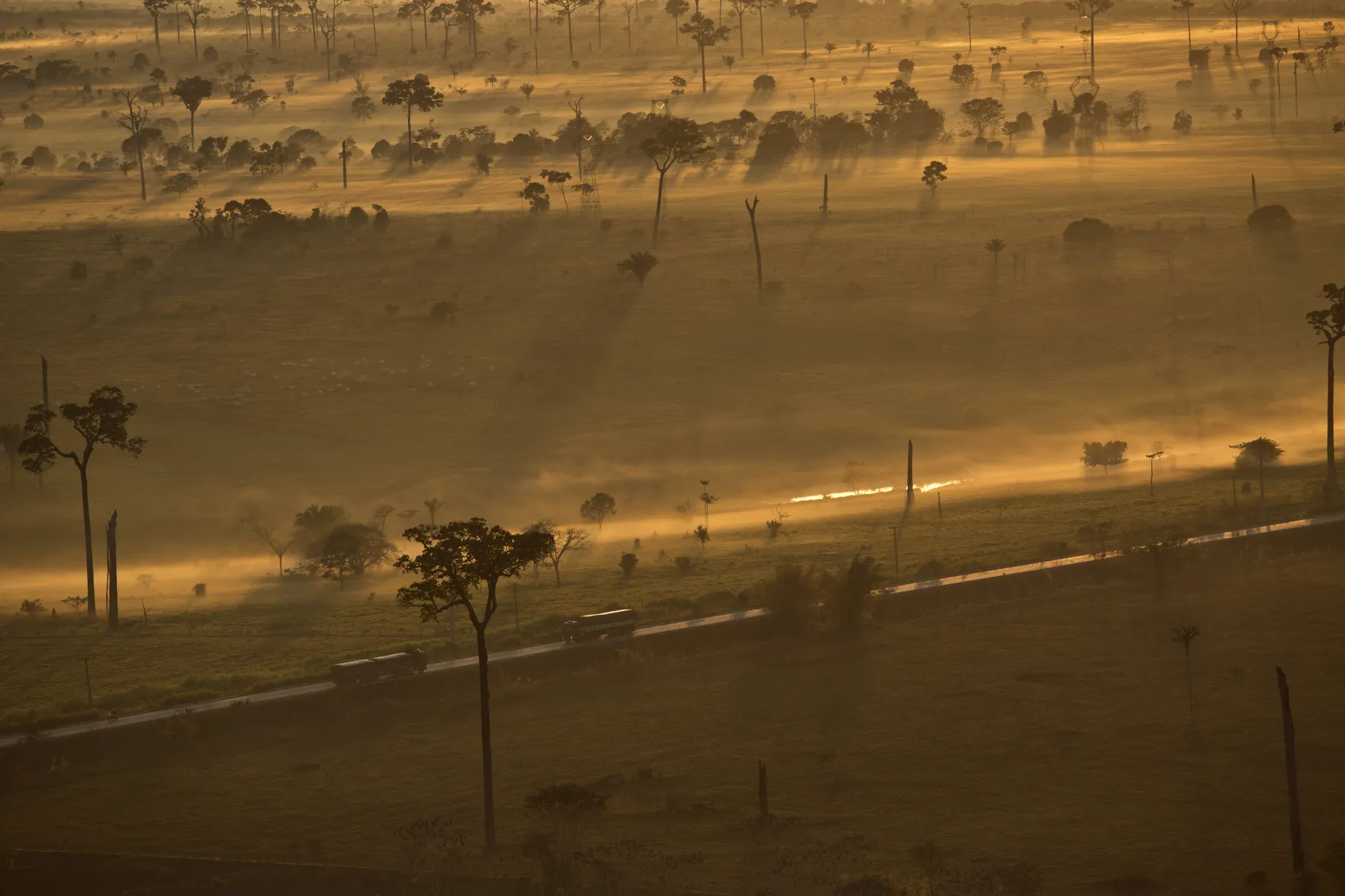 Trucks move along a road between the cities of Rio Branco and Senador Guiomard, Brazil.