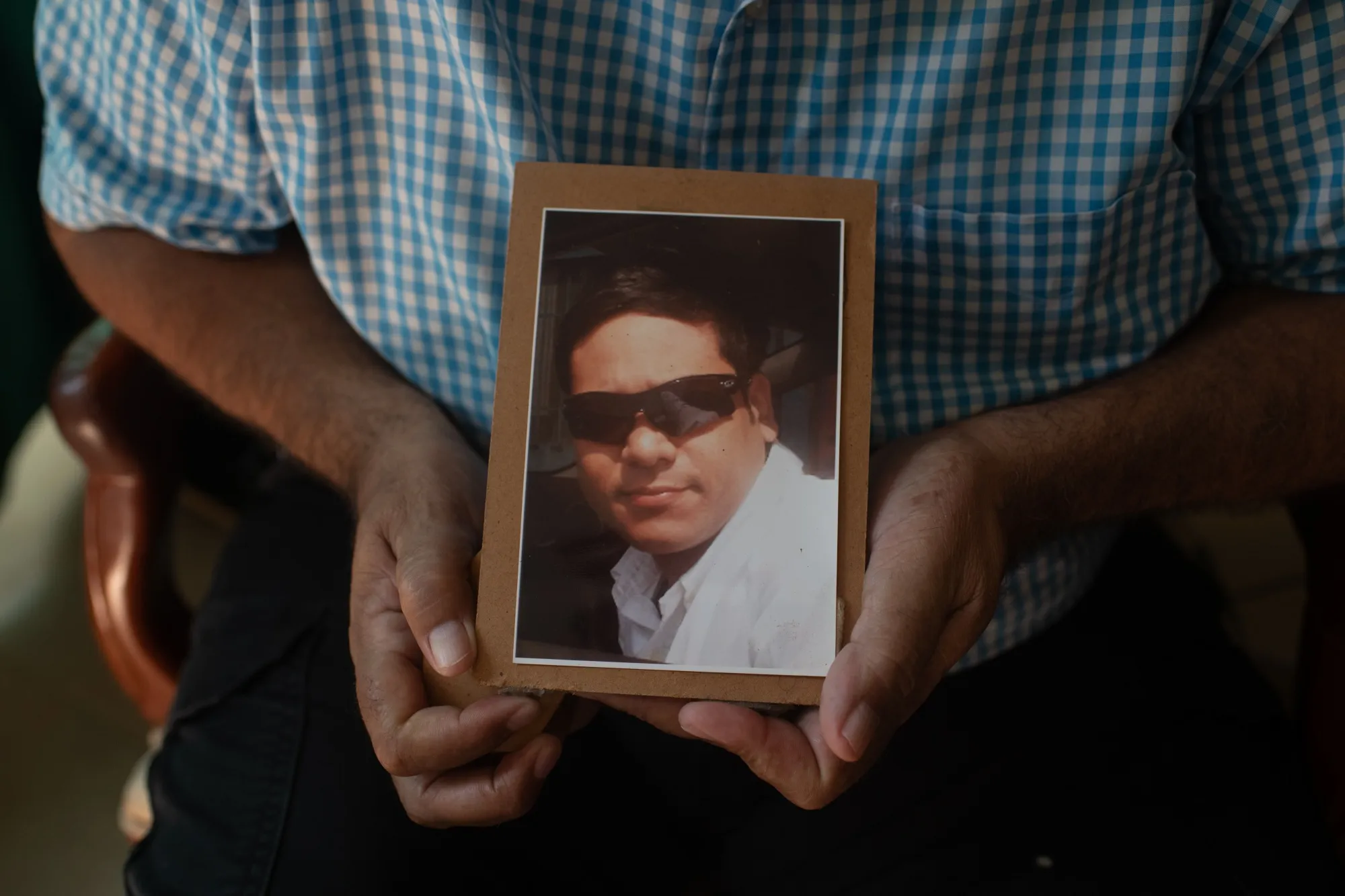 Juan Carlos Colmenarez (64) holds in his hands a photograph of his son Silverio Colmenarez (36) at home in Barquisimeto, Venezuela on Saturday Sept. 17, 2022.