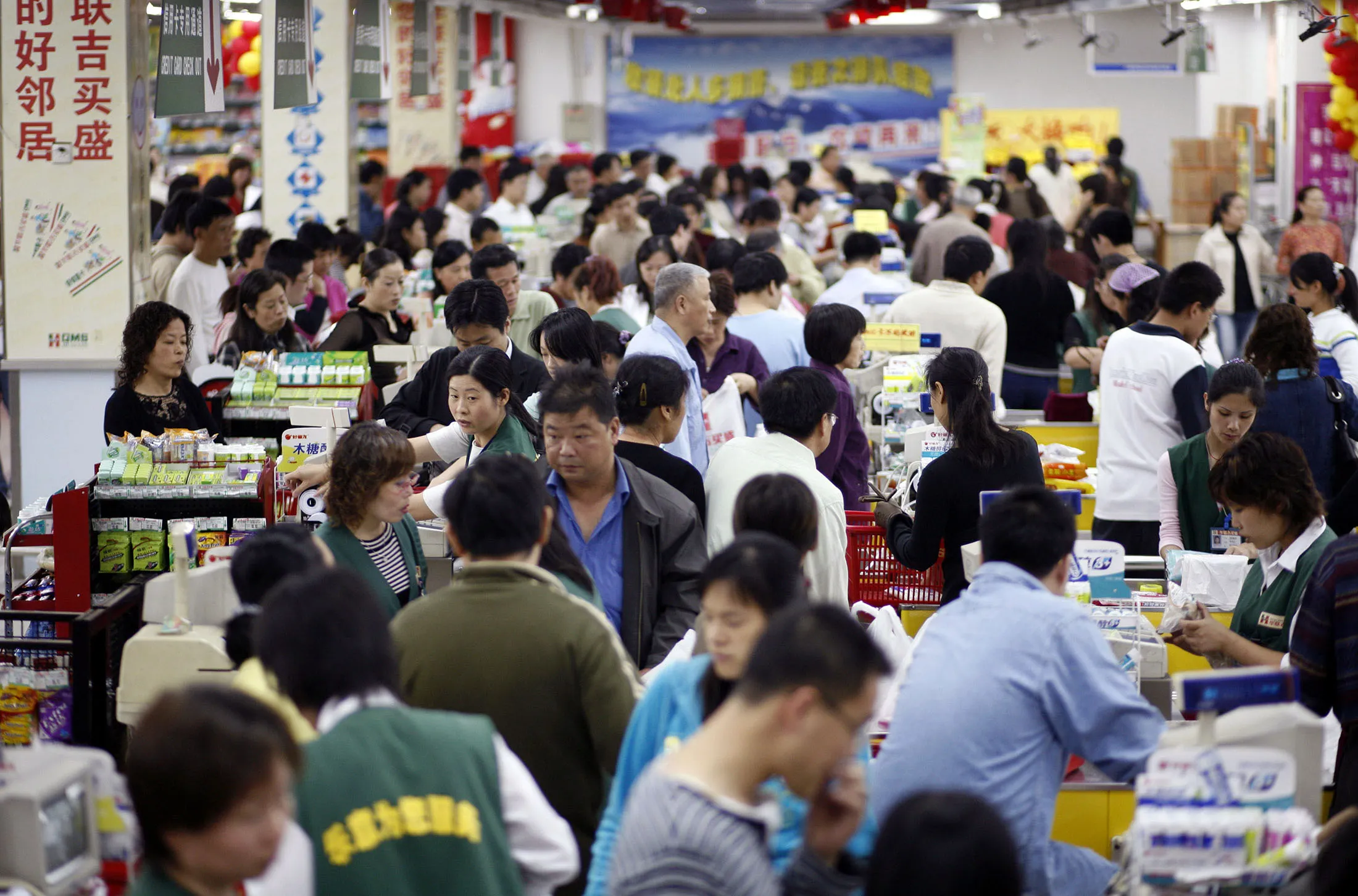 Customers go through check out counters at a GSM Hualian supermarket, owned by Shanghai Bailian Group, in Shanghai, China, Sunday, October 29, 2006. Shanghai Bailian Group will report its earnings on October 31.
