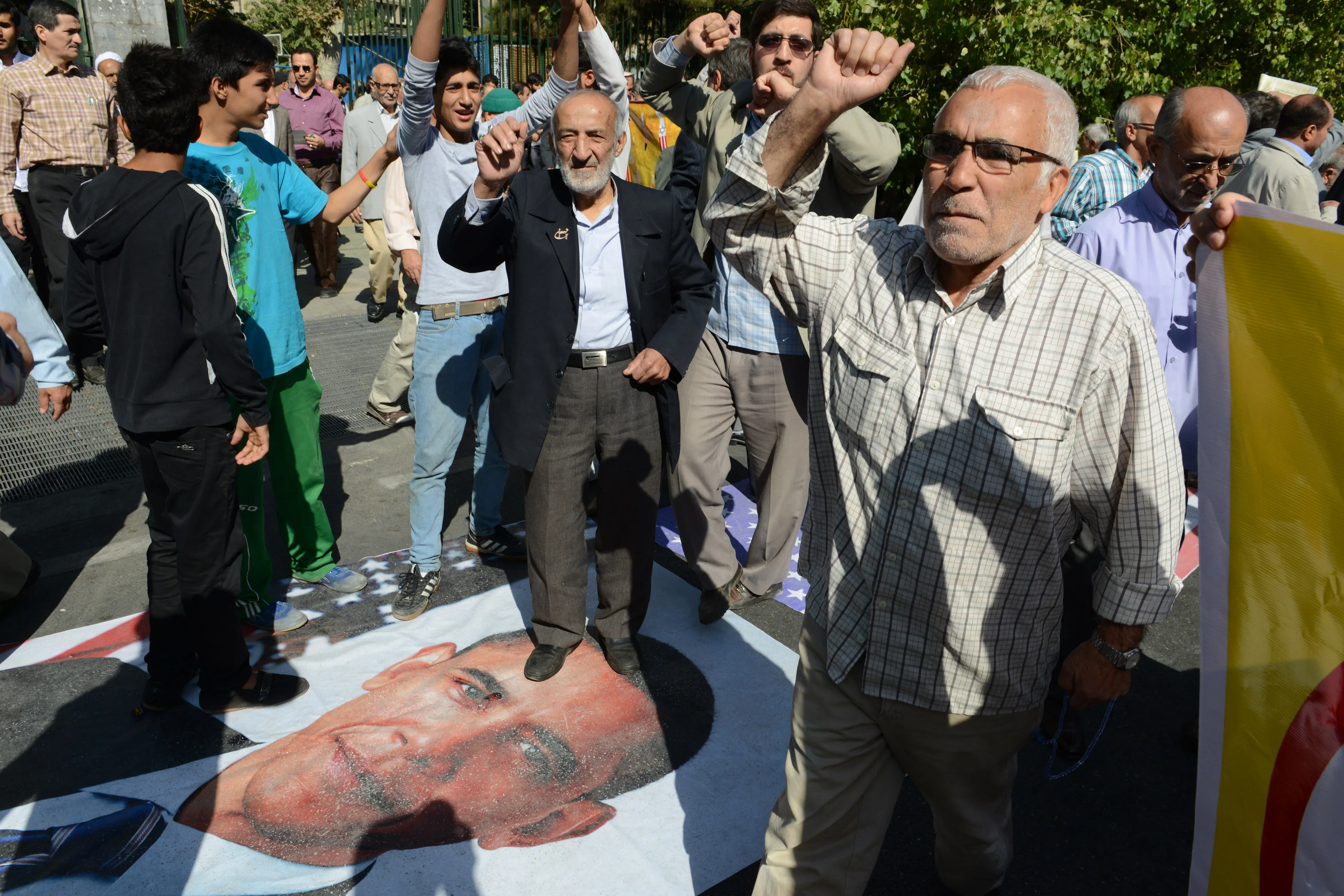 Not the biggest fans: Iranian hard-liners walk on Barack Obama's photo after prayers in Tehran.&nbsp;Photographer: Kaveh Kazemi/Getty Images