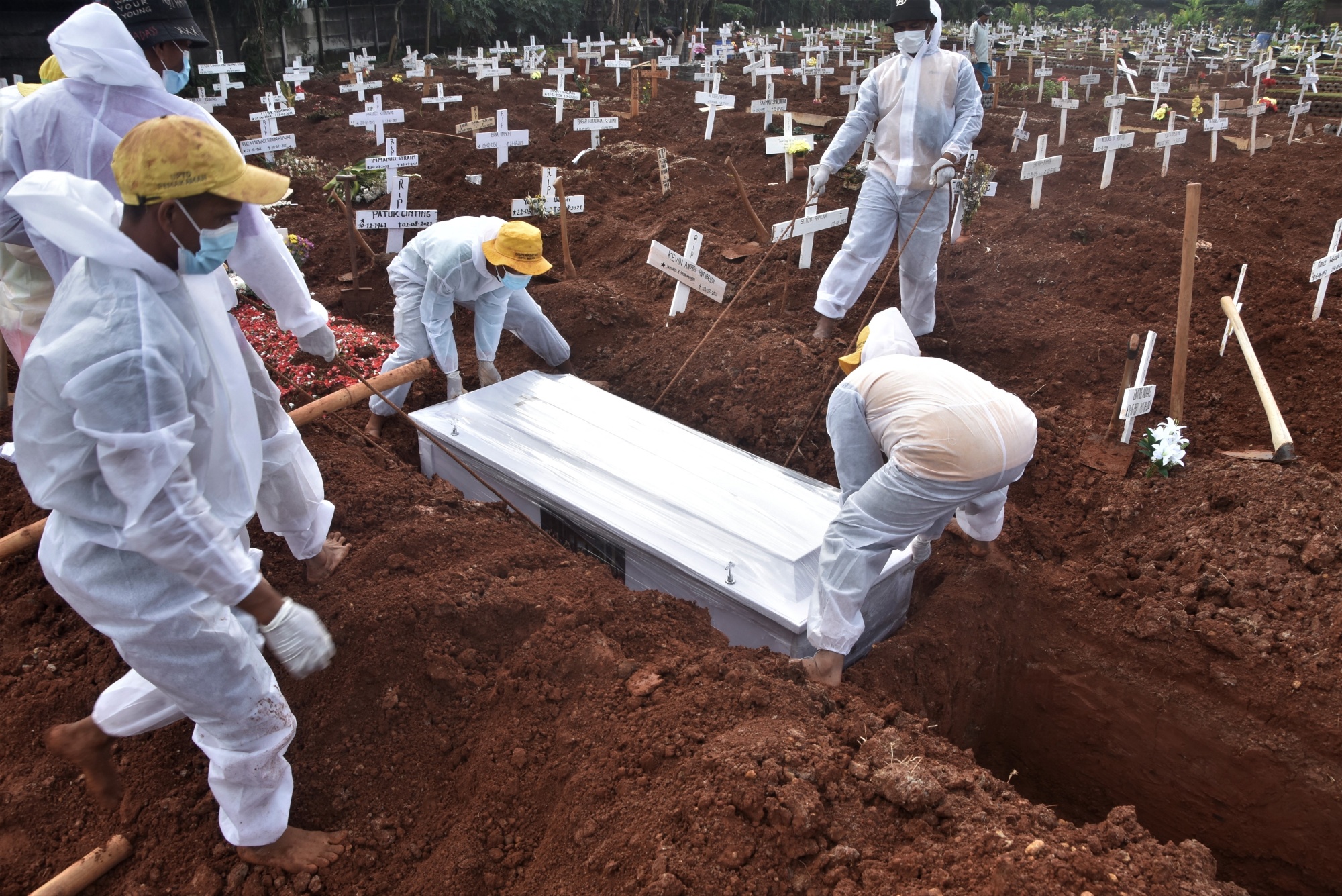 The coffin of a person who died from the coronavirus is buried at a cemetary in Bekasi, Indonesia, on Aug. 6.
