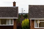 An electricity pylon next to residential properties in Little Linton, UK, on Tuesday, Aug. 26, 2025. Regulator Ofgem are due to announce their latest energy price cap levels on Aug. 27. Photographer: Chris Ratcliffe/Bloomberg