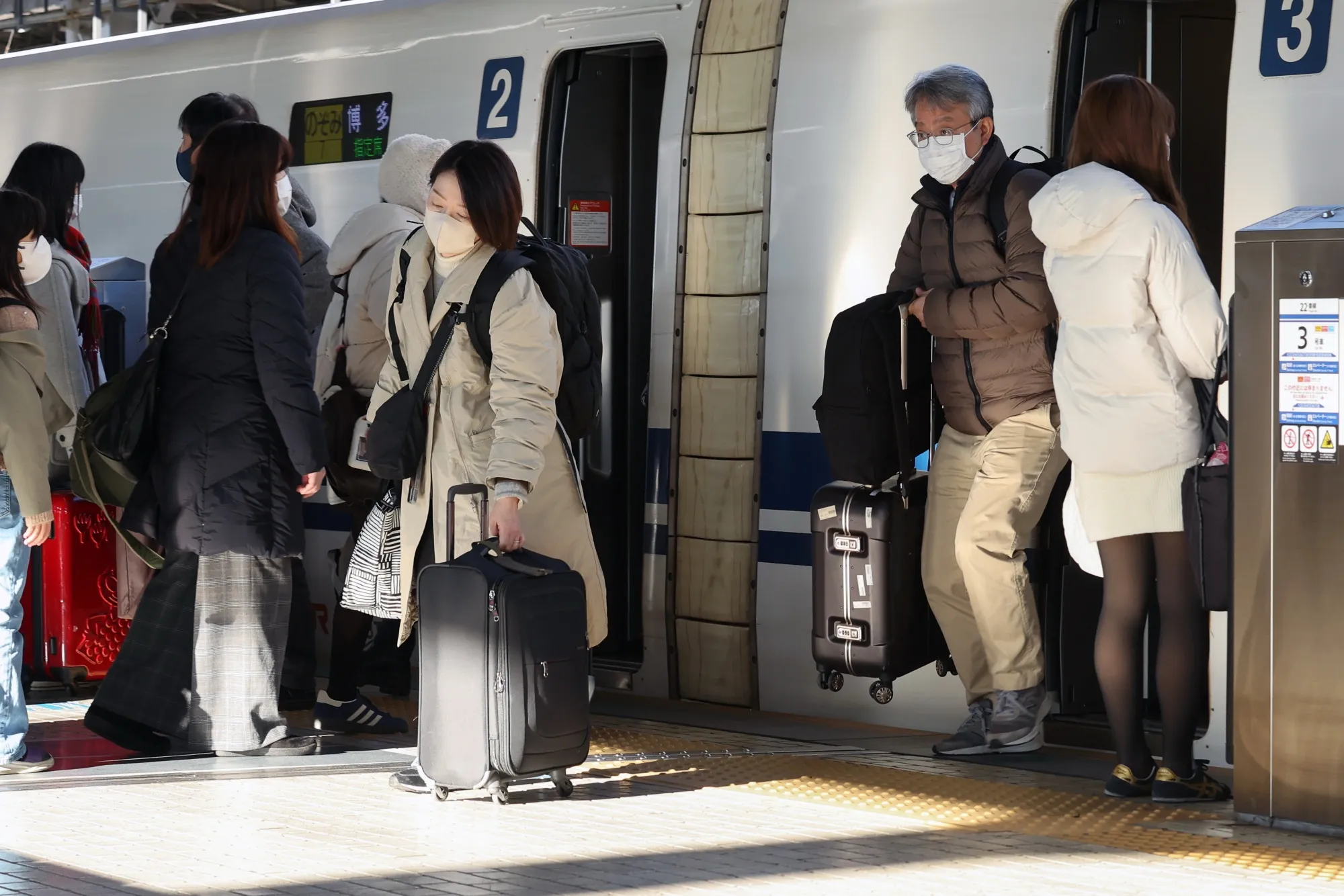 師走のJR新大阪駅で新幹線を乗り降りする乗客ら