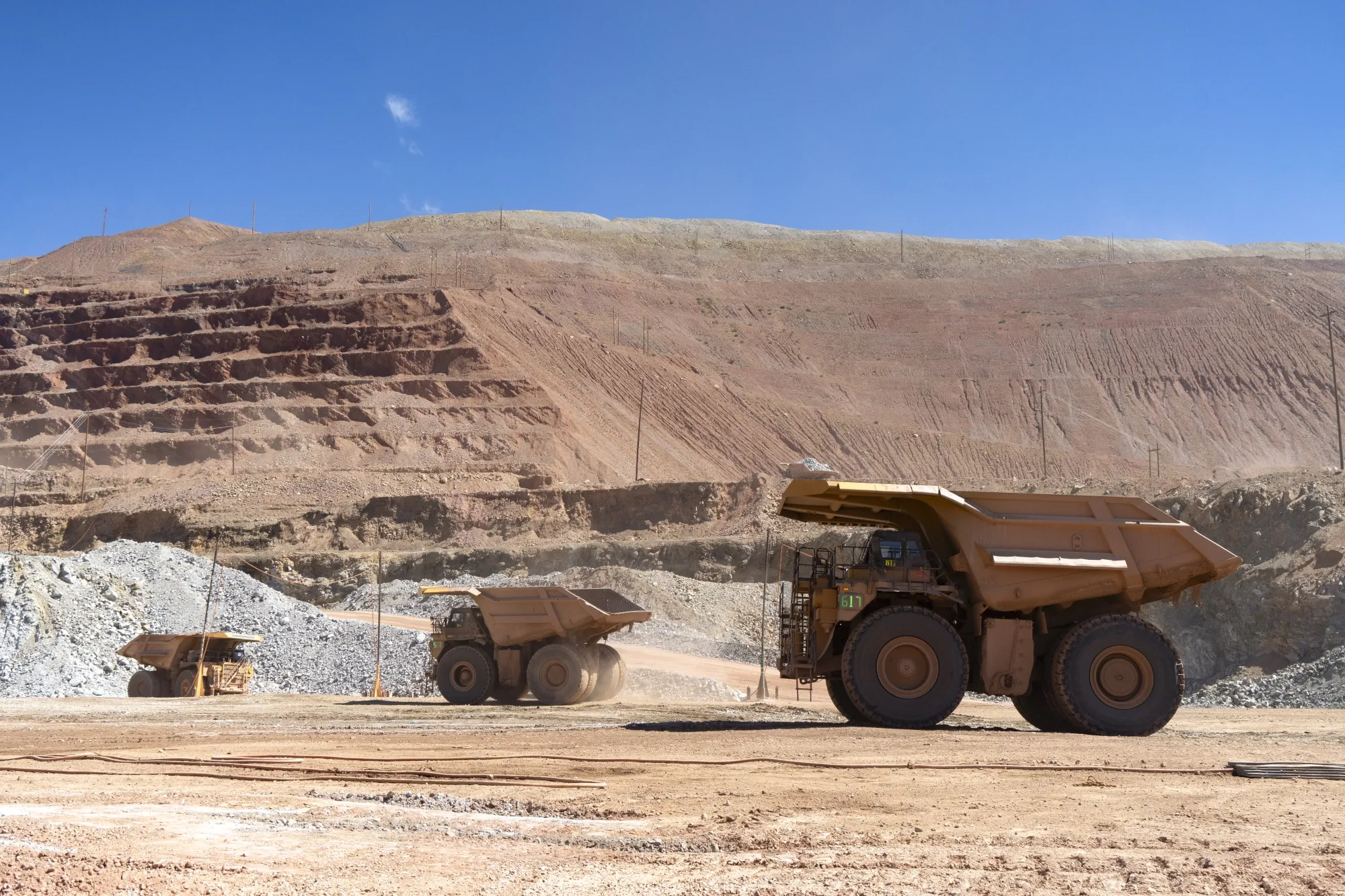 Haul trucks transport ore and waste materials at an open-pit mining complex in Morenci, Arizona.