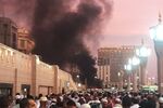 People stand by an explosion site in Medina, Saudi Arabia on Monday, July 4, 2016.
