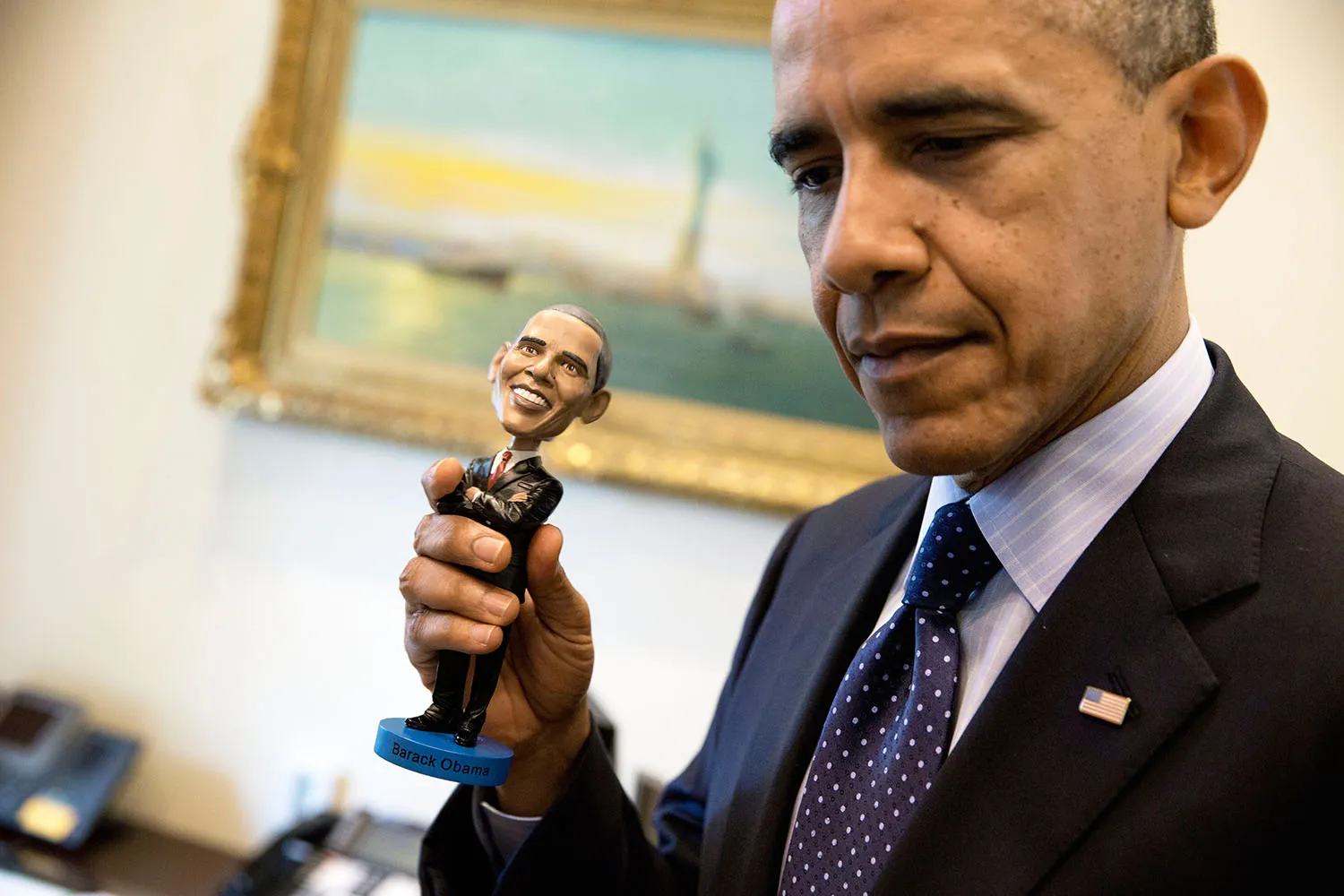 President Barack Obama holds a bobblehead doll of himsel
