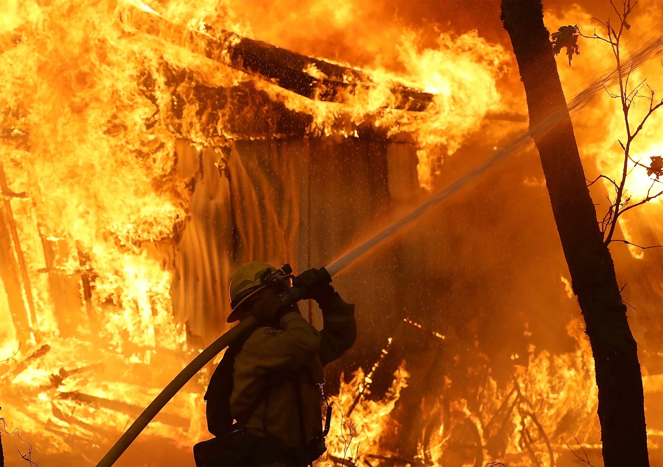 &nbsp;A Cal Fire firefighter monitors a burning home as the Camp Fire moves through the area&nbsp;in Magalia, California, on Nov. 9.&nbsp;