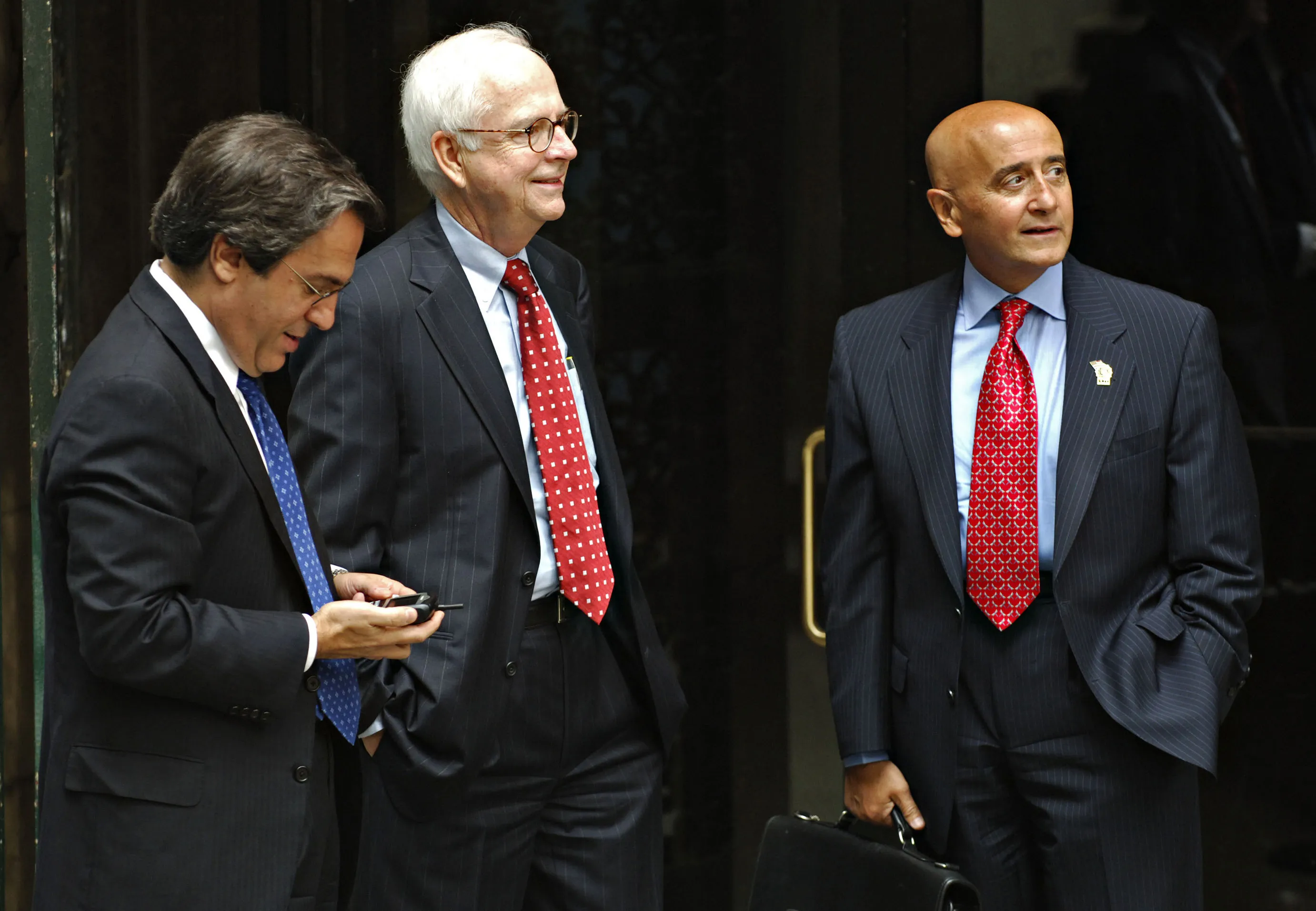 Attorneys Gerson Zweifach, left, and Brendan Sullivan, center, stand with their client Richard Grasso, right, outside court in New York, Wednesday, July 26, 2006.