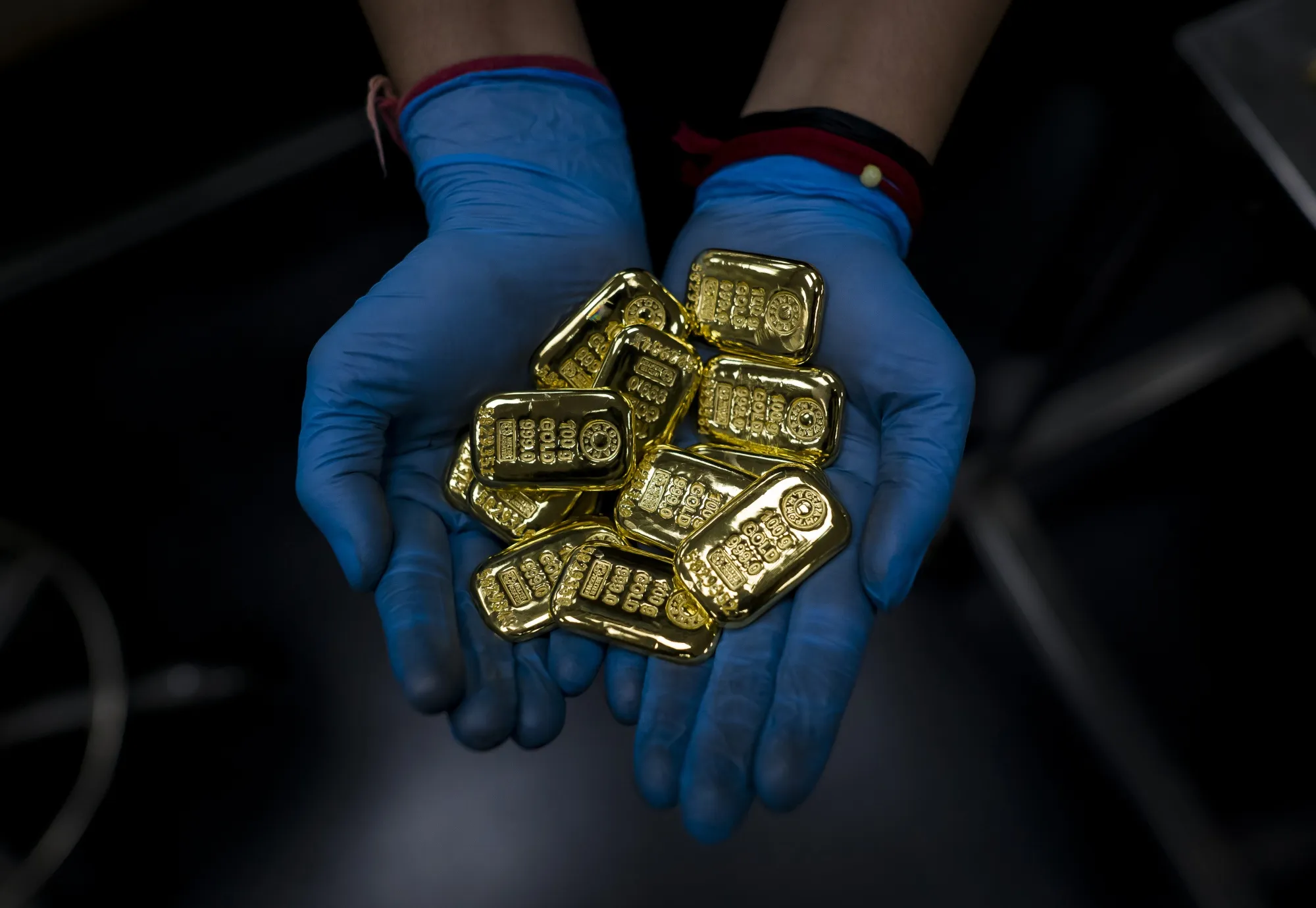 A worker displays gold bars.