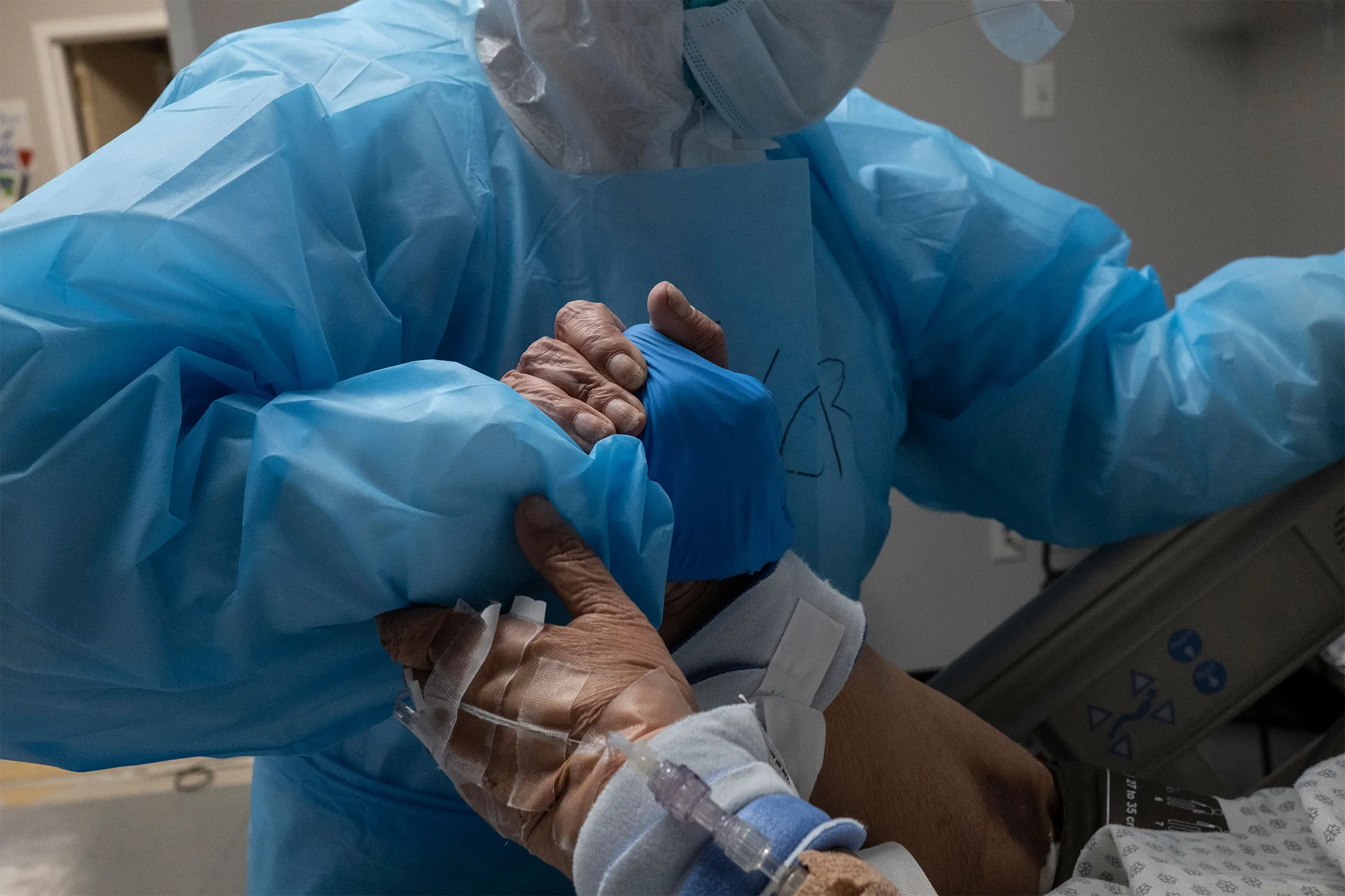 A medical worker grabs a hand of a patient&nbsp;in the Covid-19 intensive care unit at a hospital in Houston, Texas, on Oct. 31.