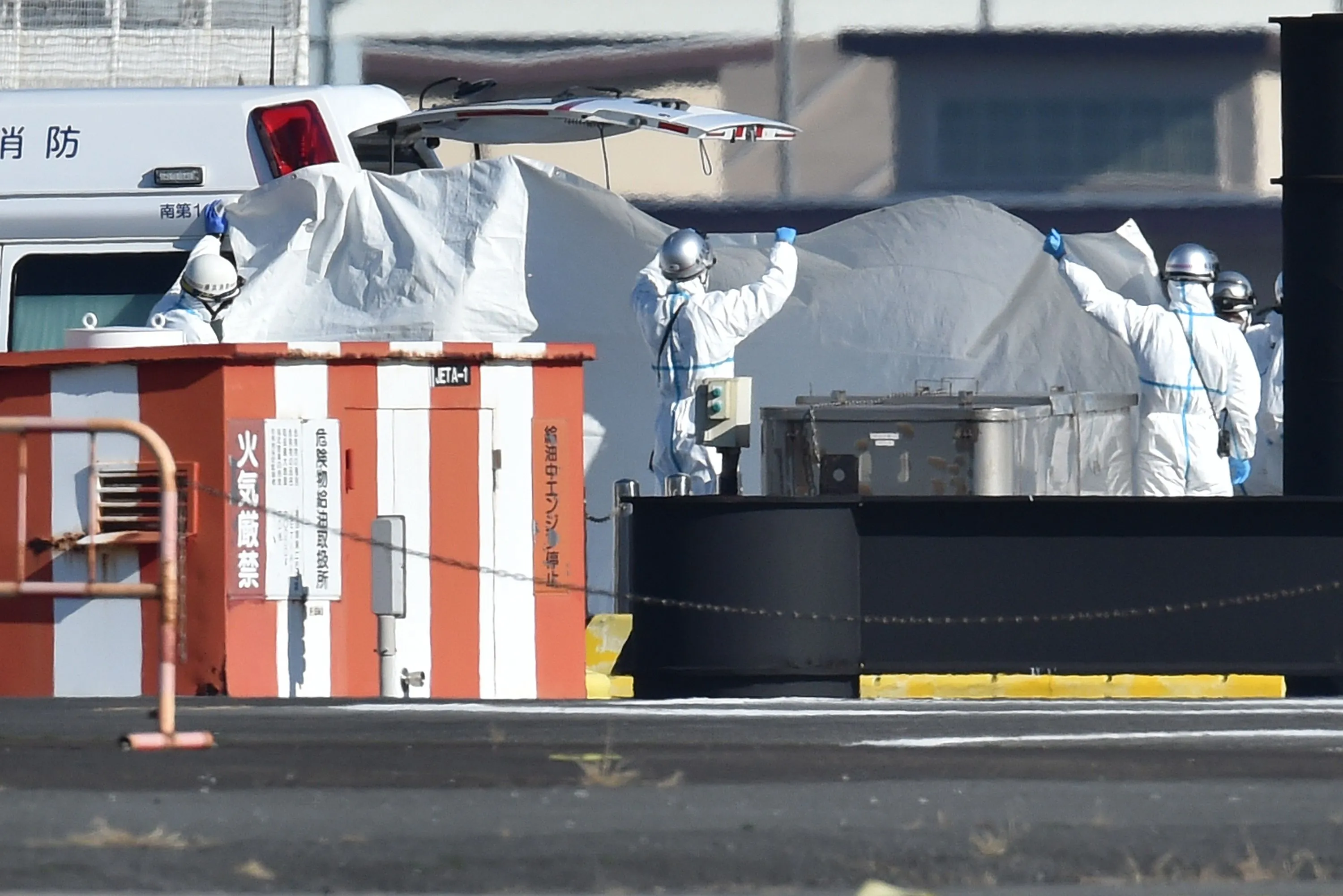 Health workers prepare to move passengers from the Diamond Princess cruise ship, in Yokohama.