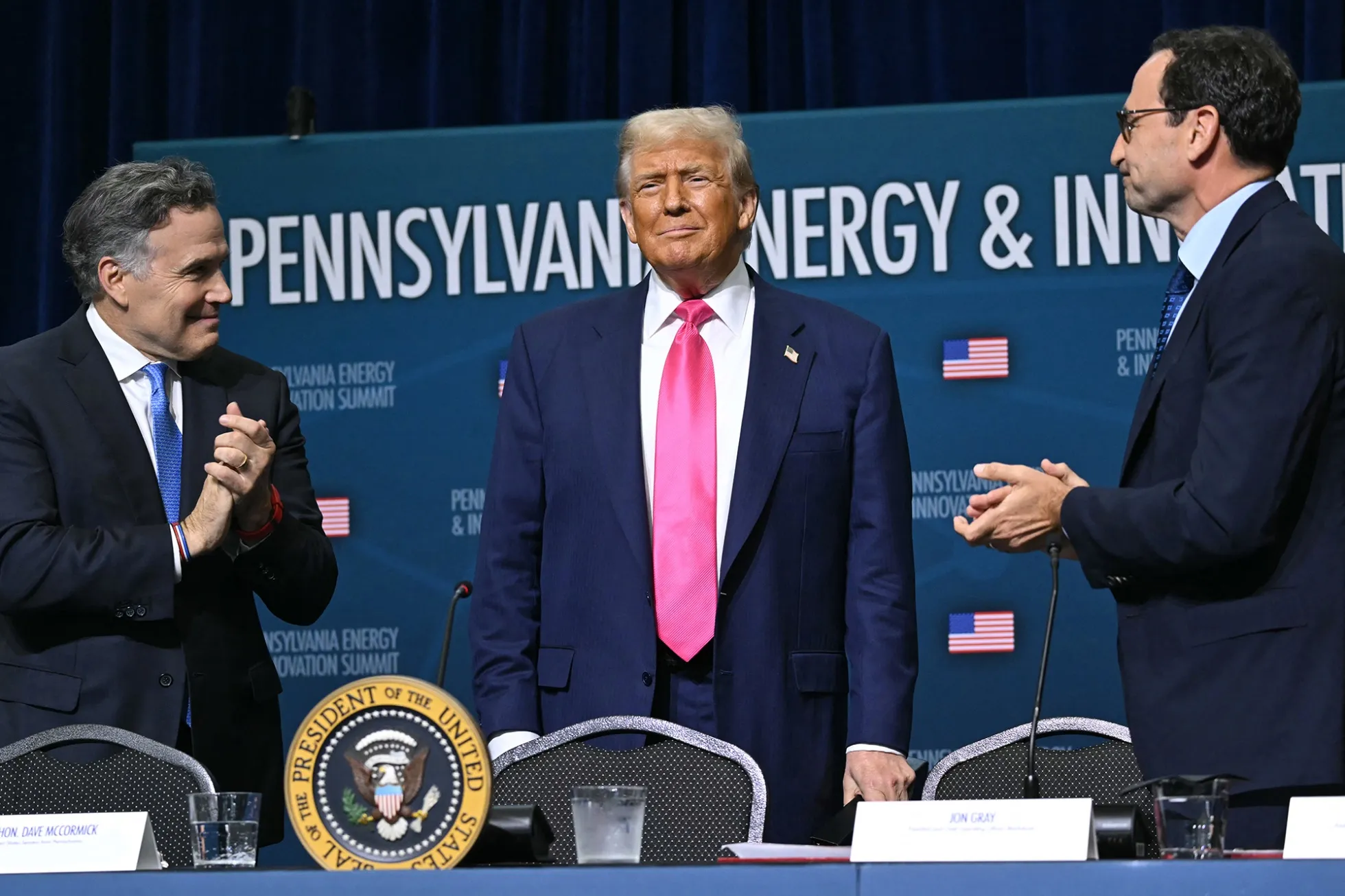 US President Donald Trump is applauded by US Senator Dave McCormick, left, and CEO of Blackstone Group Jon Gray during the Pennsylvania Energy and Innovation Summit in Pittsburgh on July 15.