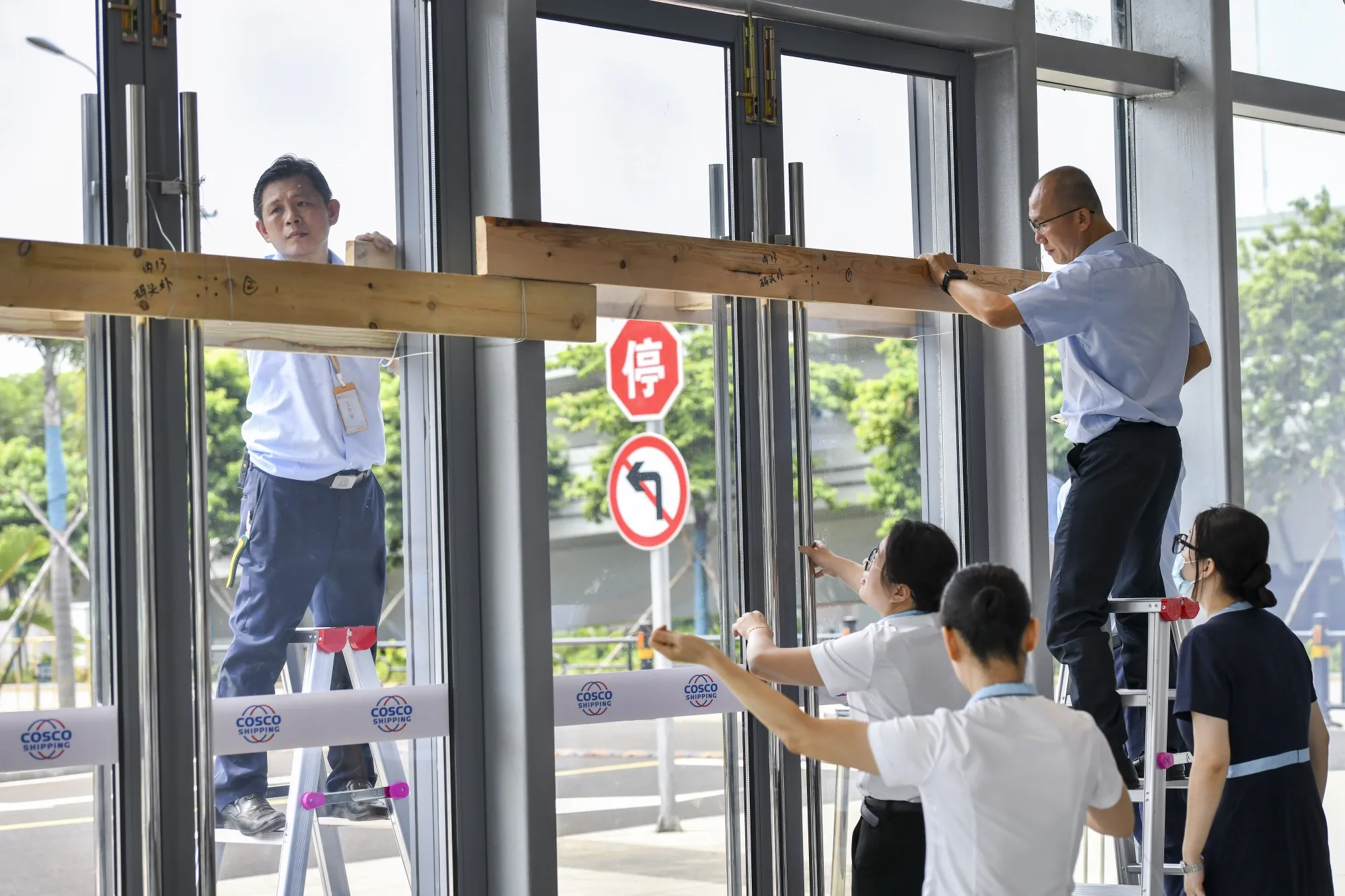 Staff members reinforce doors and windows bracing for the Typhoon Yagi at Xinhai Port in Haikou, Hainan Province, on Sept. 4.
