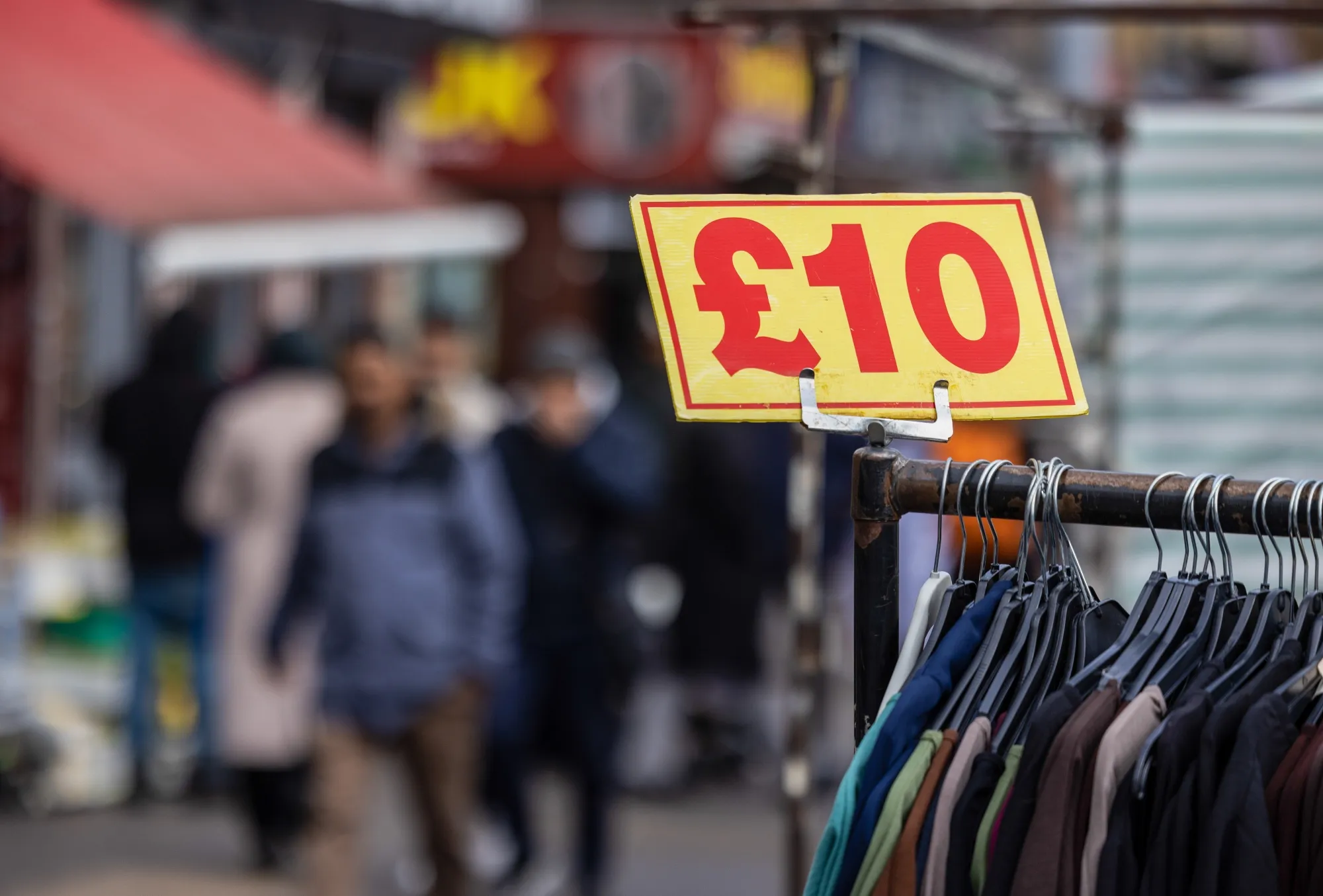 A price label on racks of clothing on a market stall in the Tower Hamlets borough of London.