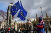 Anti-Brexit campaigners wave European Union (EU) flags near the Houses of Parliament in London, U.K., on Wednesday, March 13, 2019. Britain will confront head-on the threat of a no-deal Brexit in a parliamentary vote with huge ramifications for Prime Minister Theresa May.