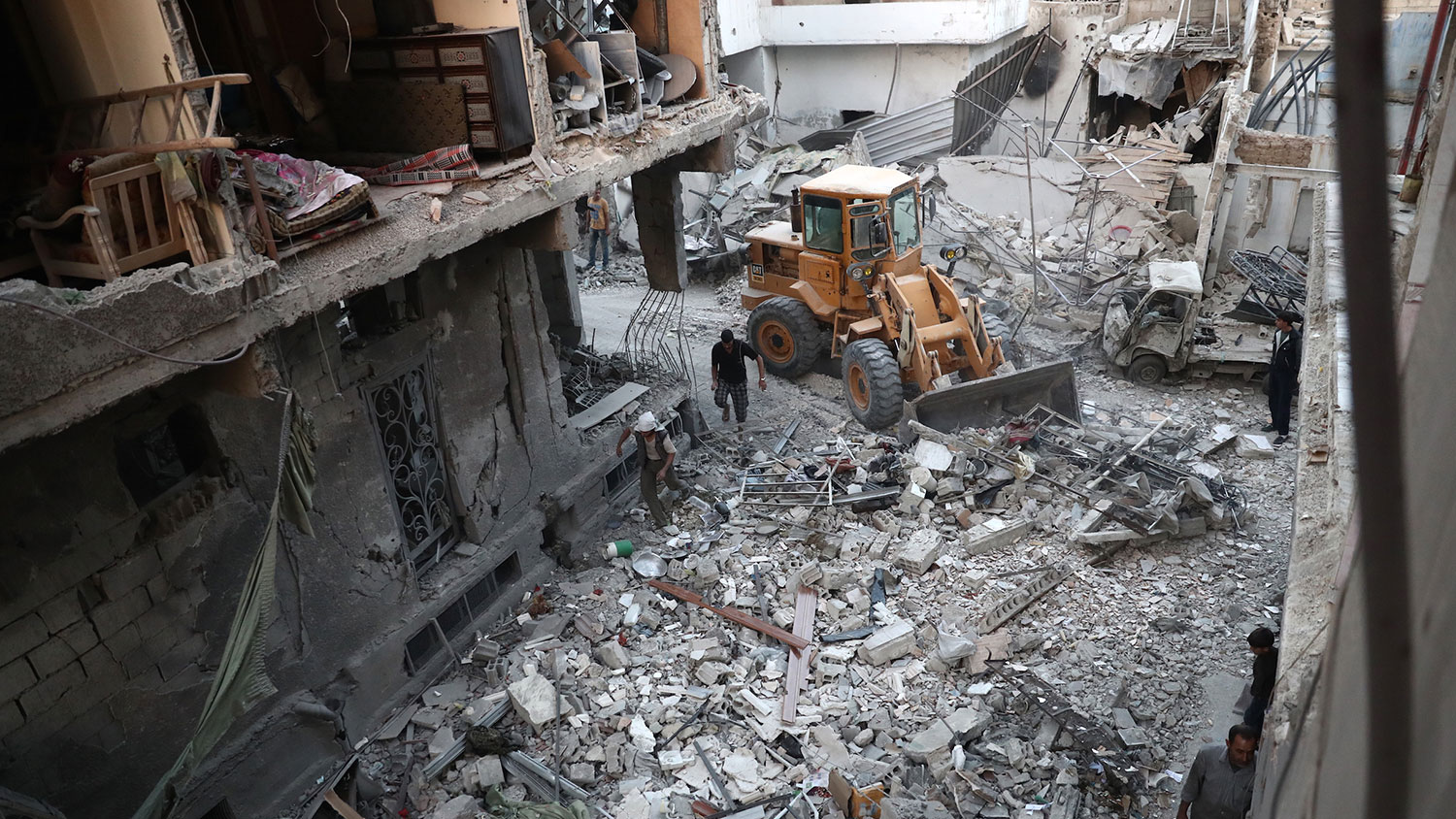 A digger removes the rubble of destroyed buildings on Oct. 3, 2016, following reported air strikes in the rebel-held town of Douma, on the eastern outskirts of the capital Damascus.
