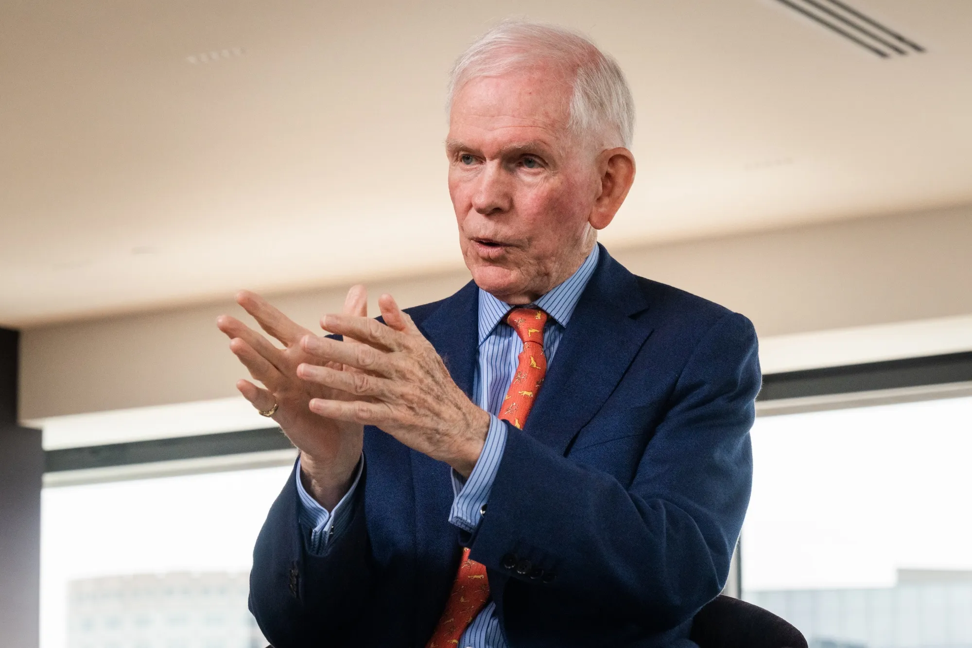 Jeremy Grantham in a navy suit with an orange tie