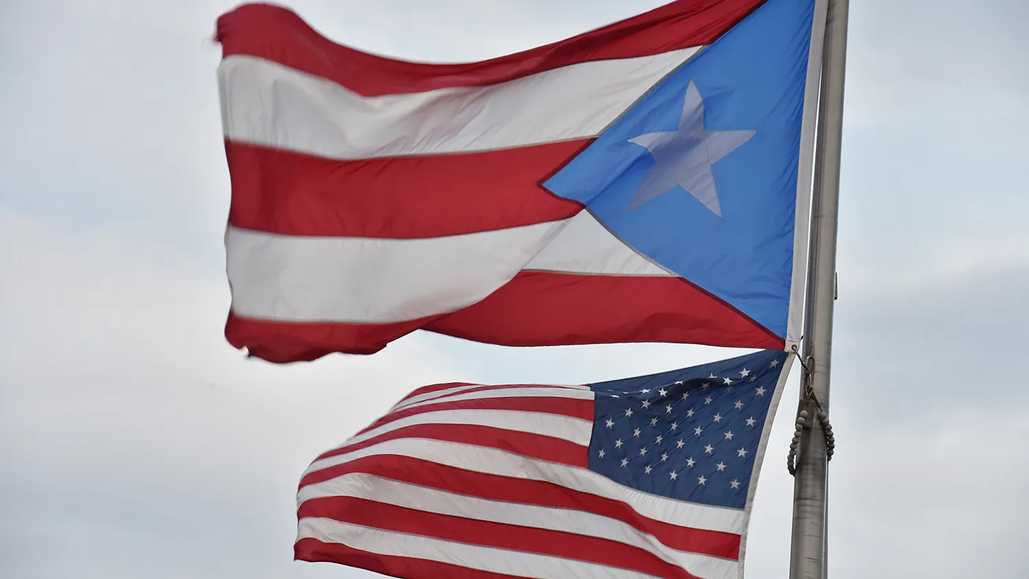 The Puerto Rican and US flags are seen in the Old Town district February 9, 2015 in San Juan, Puerto Rico.
