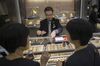 An employee holds Hong Kong dollar banknotes as he serves customers inside a Lukfook Jewellery store, operated by Luk Fook Holdings International Ltd., in the Tsim Sha Tsui district in Hong Kong, China, on Thursday, Aug. 21, 2014. Luk Fook, the second-largest jeweler in Hong Kong by market value, plans to expand in the city's prime shopping districts as landlords hold back on raising rents.