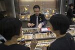 An employee holds Hong Kong dollar banknotes as he serves customers inside a Lukfook Jewellery store, operated by Luk Fook Holdings International Ltd., in the Tsim Sha Tsui district in Hong Kong, China, on Thursday, Aug. 21, 2014. Luk Fook, the second-largest jeweler in Hong Kong by market value, plans to expand in the city's prime shopping districts as landlords hold back on raising rents.