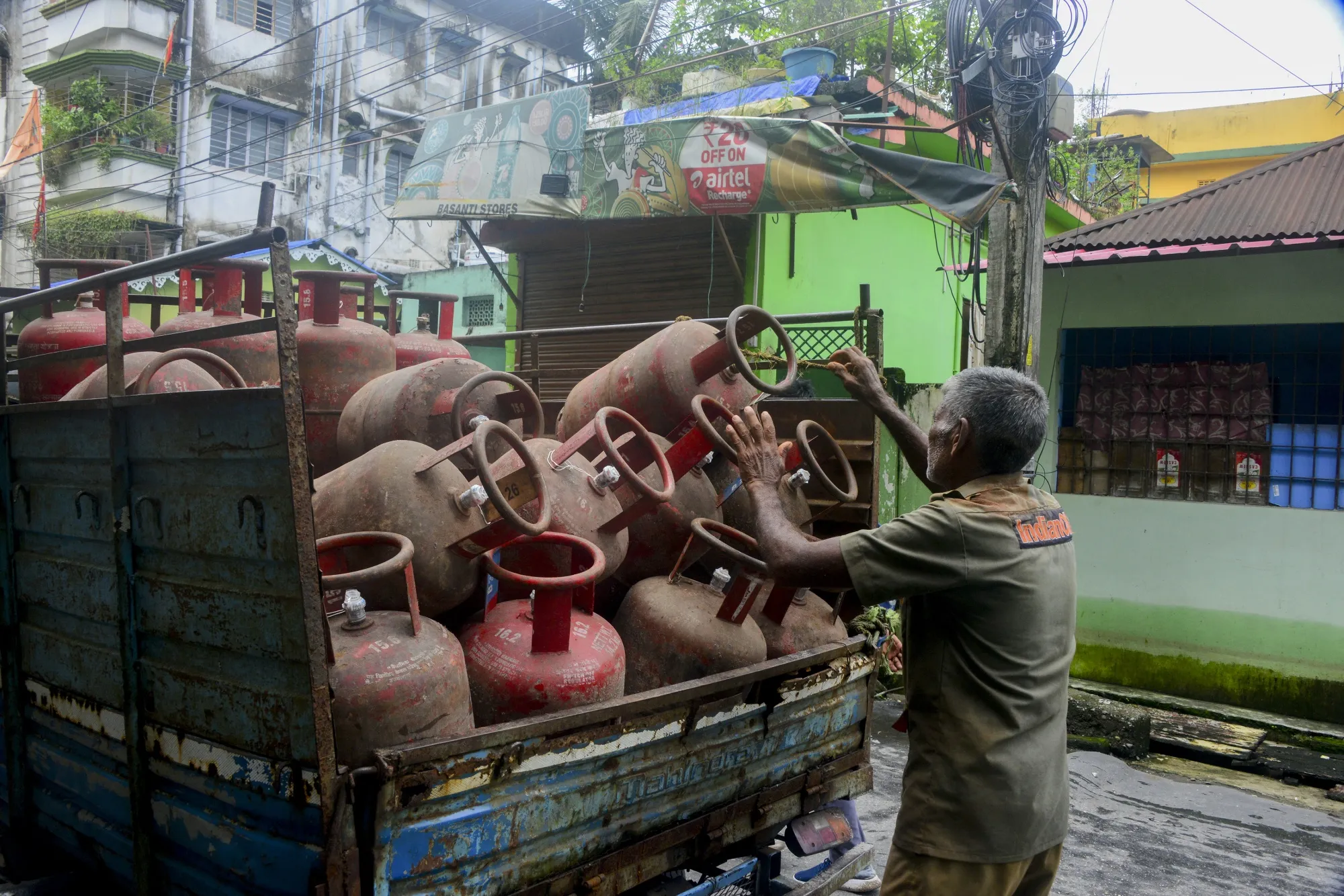 A delivery worker unloads domestic gas cylinders from a truck in Siliguri, India.