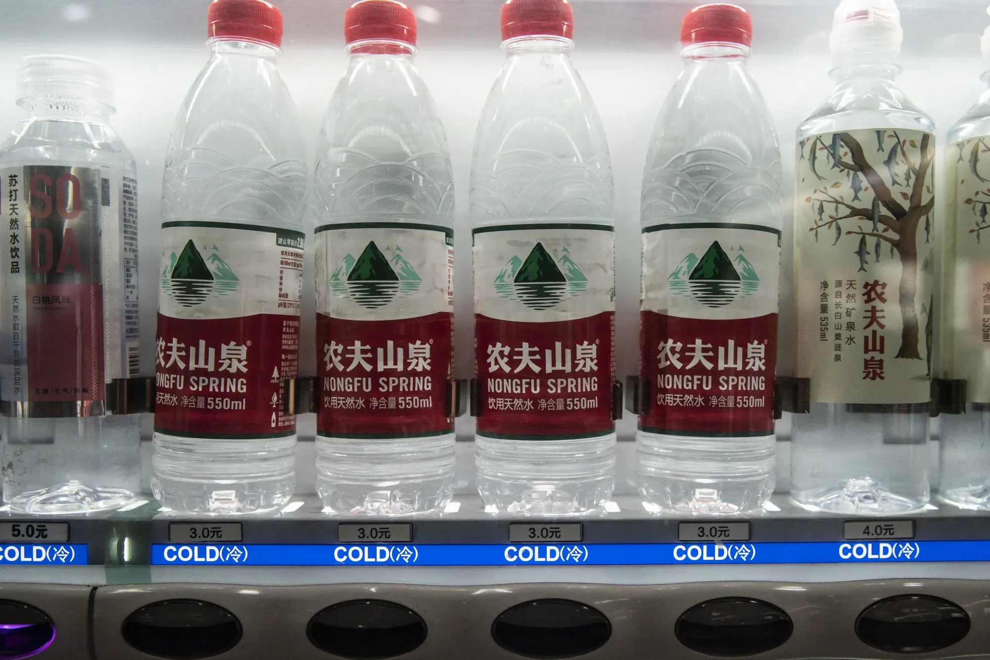 Bottles of Nongfu Spring Co. water at a vending machine in Shanghai. The chairman of&nbsp;Nongfu, a bottled-water company that's ubiquitous in China, is now richer than&nbsp;Warren Buffett.