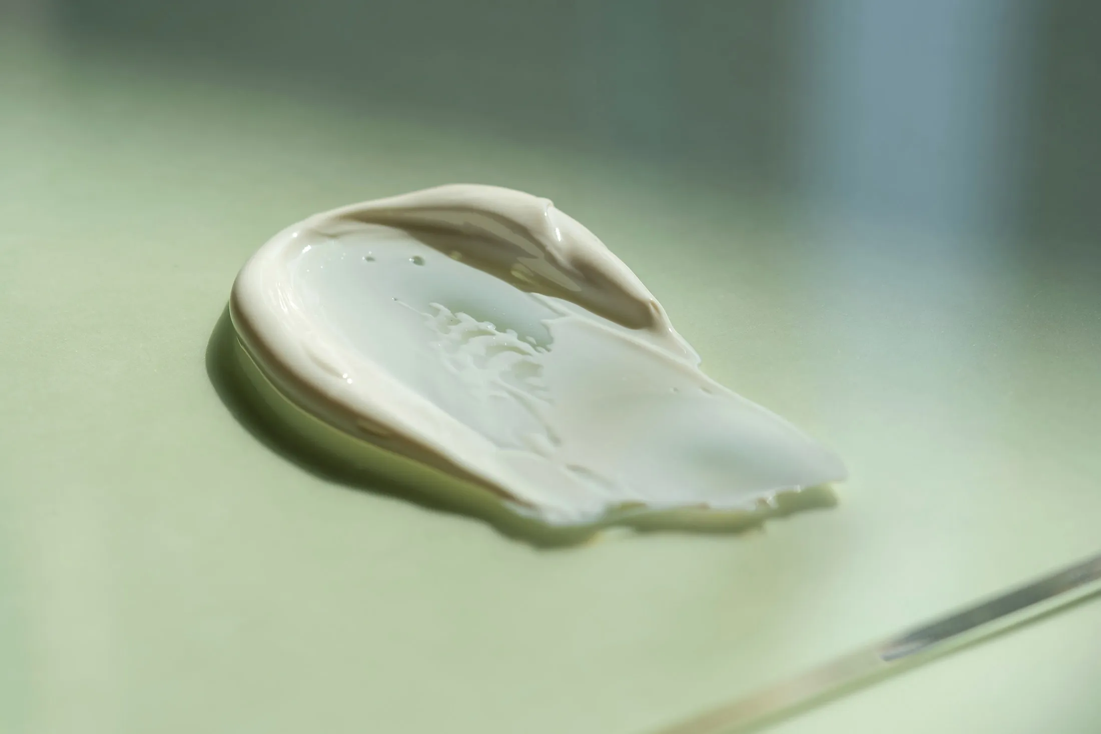 The texture of the cream on a green natural background.