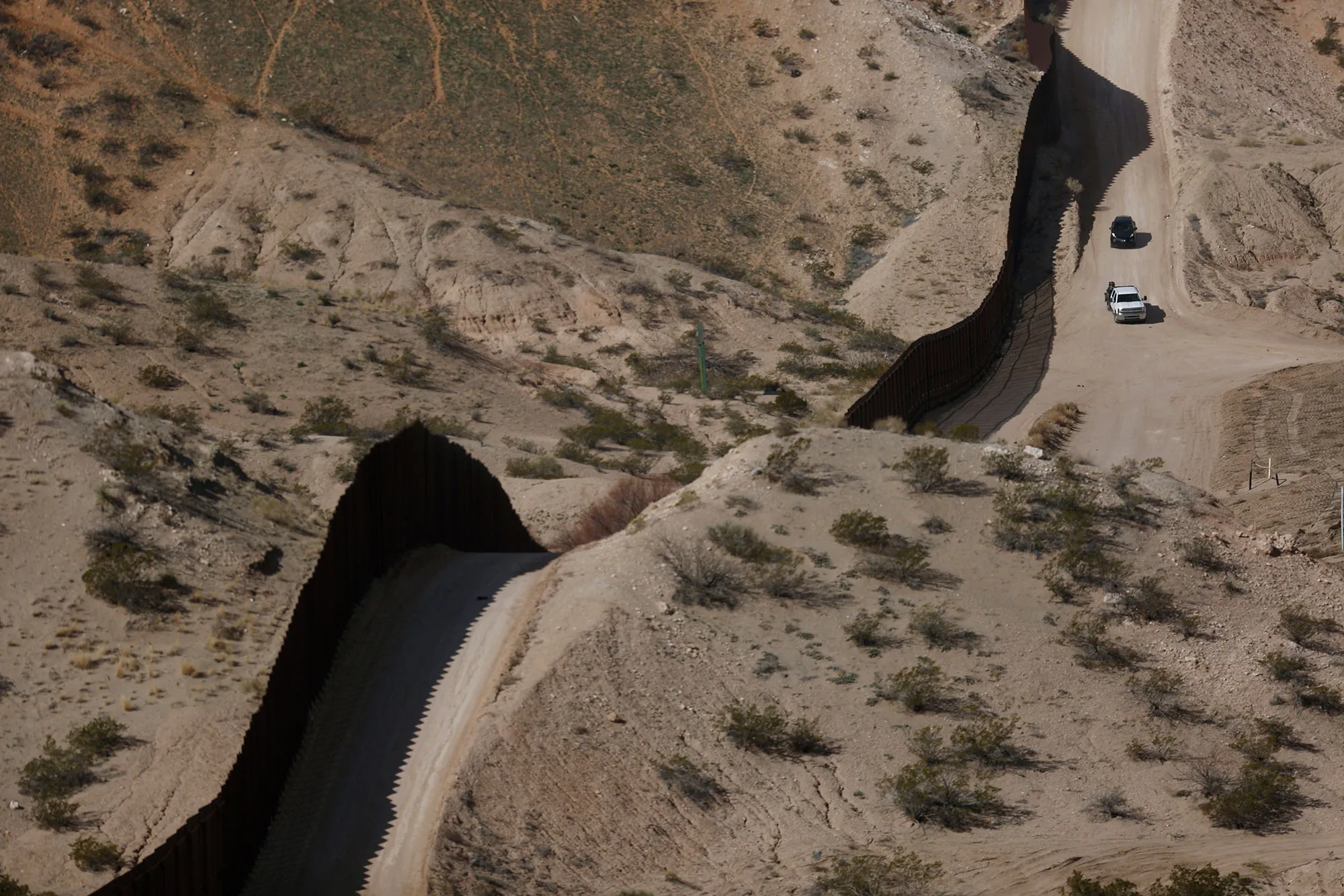 Vehicles drive past a section of a border fence that separates the U.S. and Mexico in Sunland Park, New Mexico, on Feb. 17.
