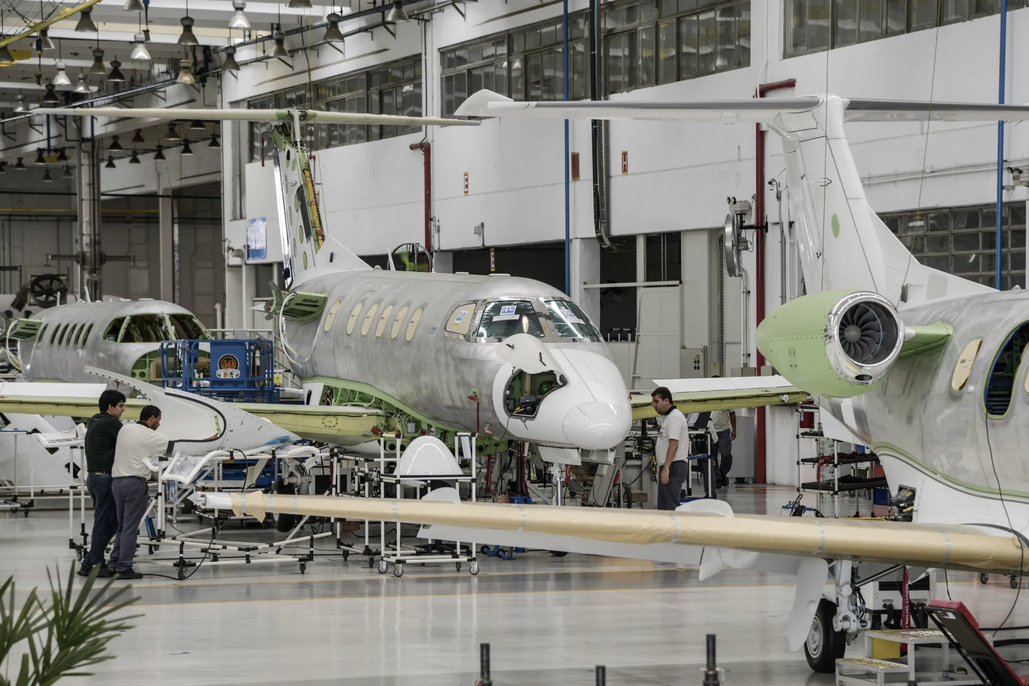 Employees work on a Phenom 300 jet on the assembly line at the Embraer SA manufacturing plant in Sao Jose dos Campos, Sao Paulo state, Brazil.