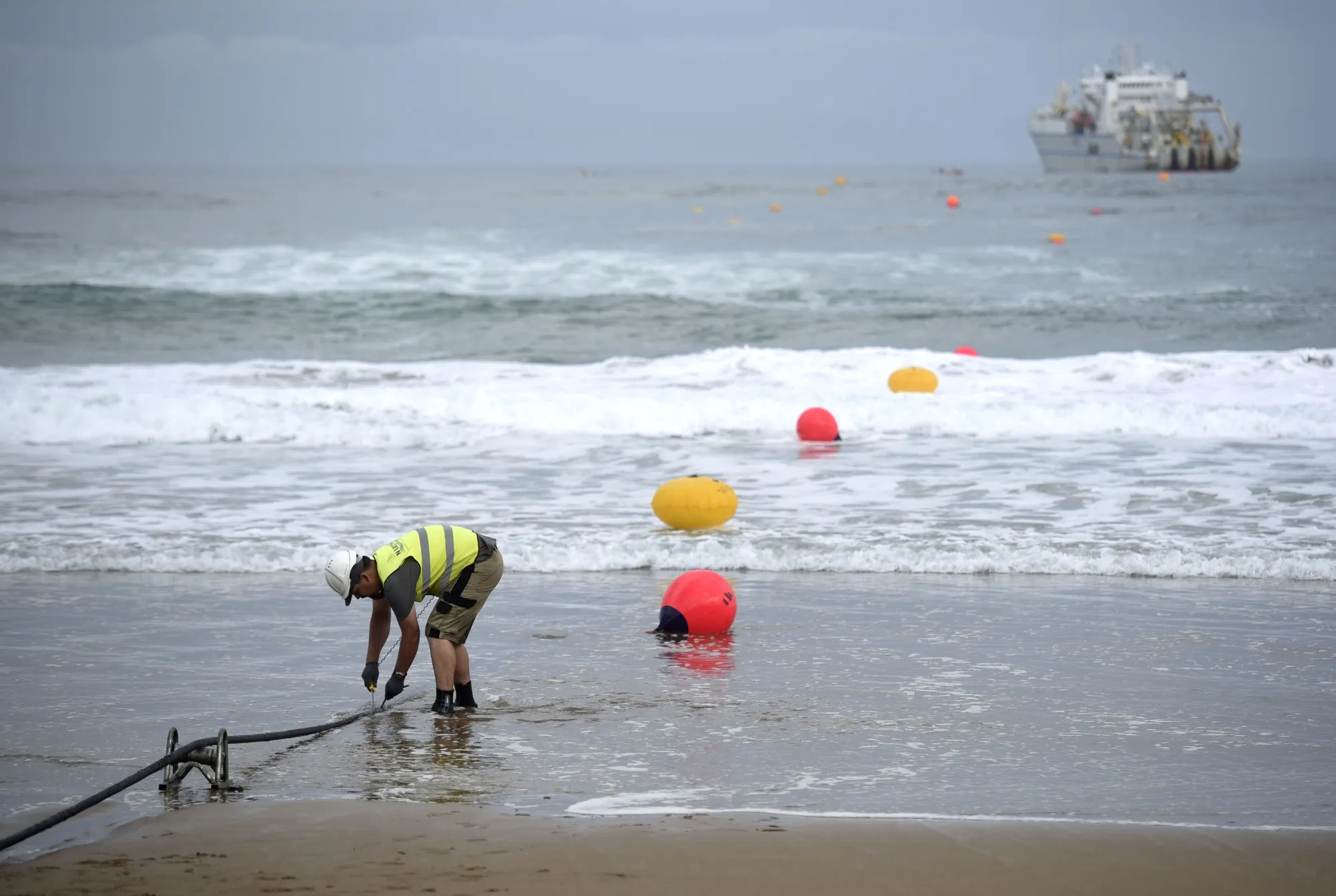 An operator adjusts an undersea fiber optic cable.
