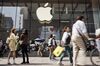 Pedestrians walk past an Apple Inc. store in Shanghai, China.