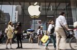 Pedestrians walk past an Apple Inc. store in Shanghai, China.